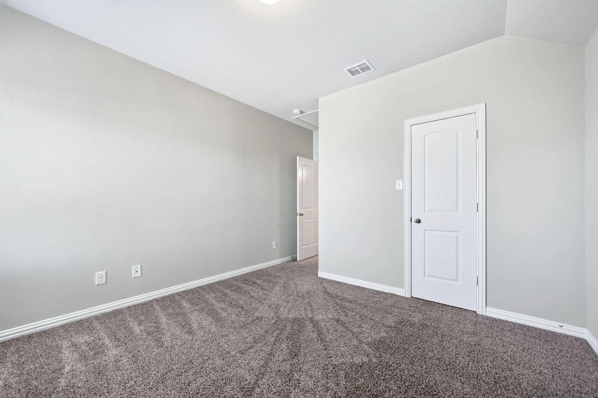 Neutral wall palette featuring textured finishes, wall-to-wall carpeting, and white interior paneled doors