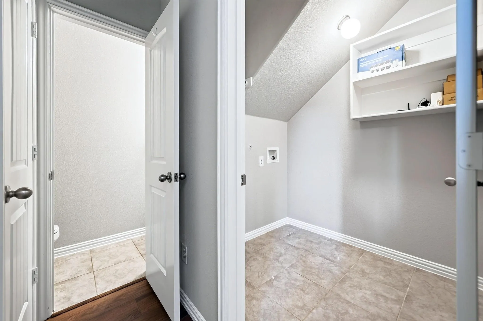 Utility room featuring tile flooring, built-in shelving, and washer-dryer hookups