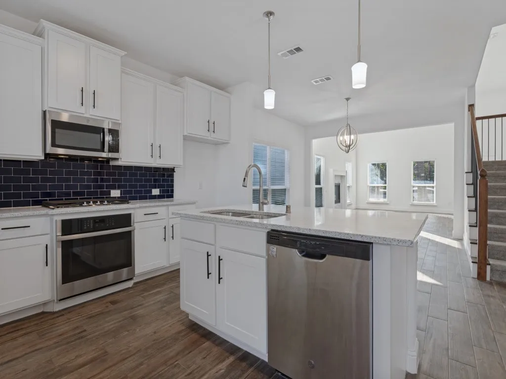 Spacious kitchen with generous cabinet storage, a contrasting tile backsplash, and an open layout.