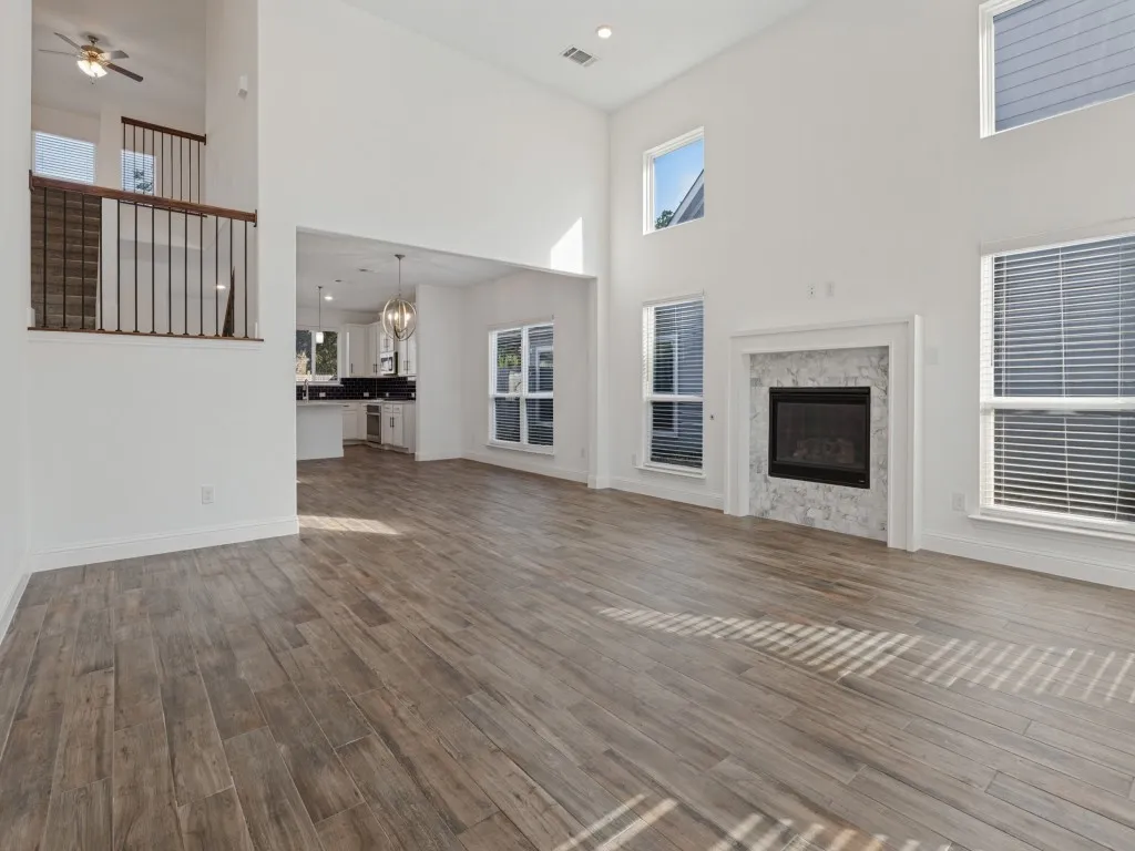 Open living area with wood-look tile flooring and views of the upstairs loft