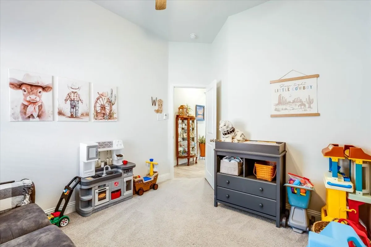 Room featuring high ceilings, neutral wall tones, neutral carpeting, and a traditional door entry