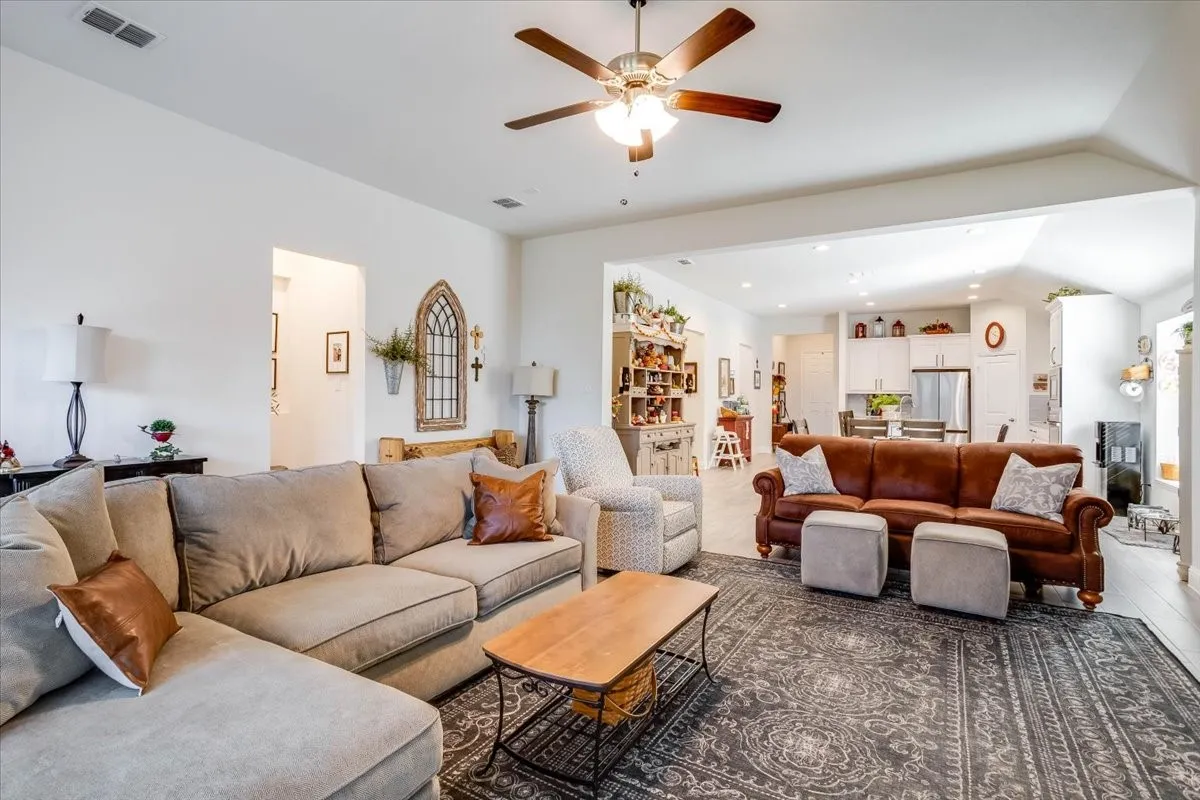 Open-concept interior featuring high ceilings, recessed lighting, and a multi-blade ceiling fan with integrated light fixture