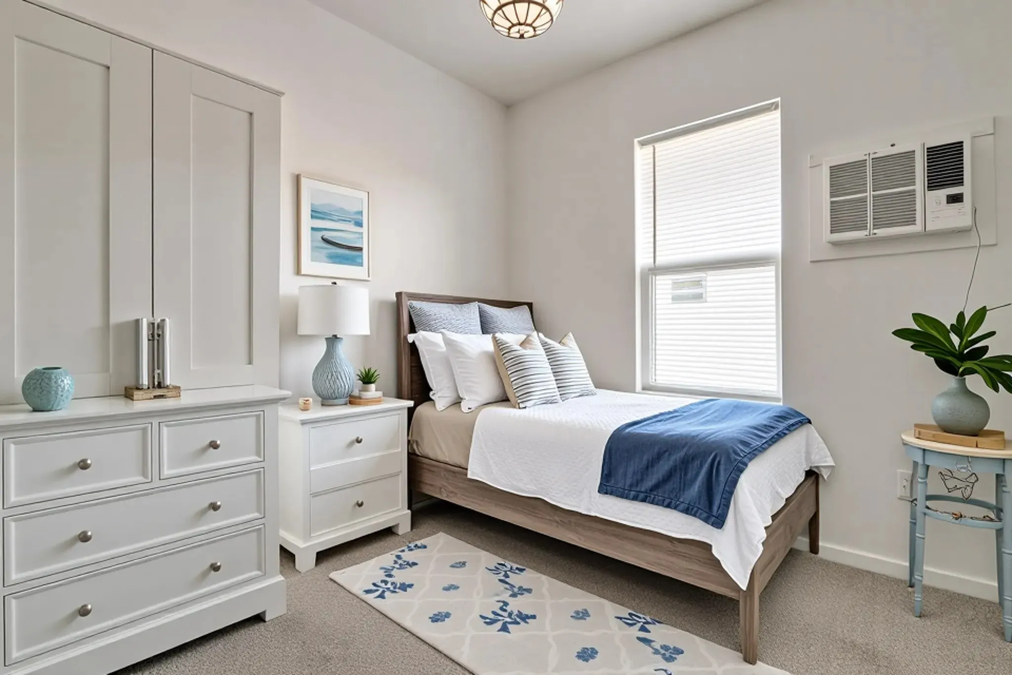 Room featuring neutral-toned carpeting, a built-in cabinetry unit with shaker-style doors and drawers, a single-hung window with integrated blinds, a semi-flush mount light fixture, and a wall-mounted cooling unit