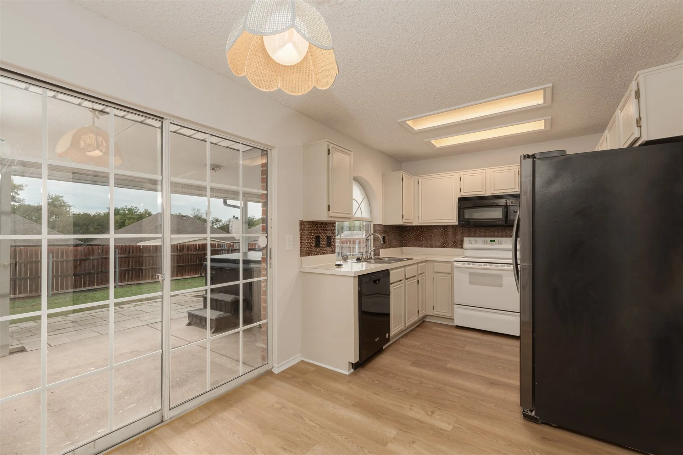 Bright kitchen, breakfast room and view of back patio