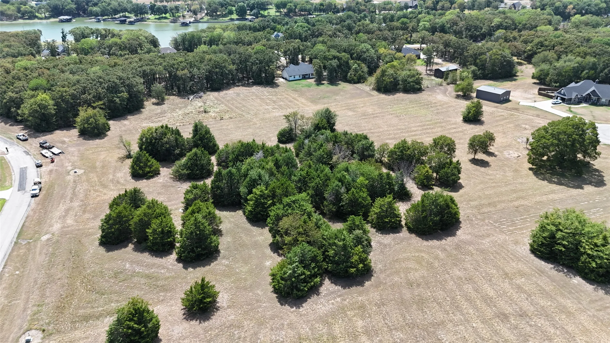 Expansive acreage featuring clusters of mature trees, open terrain, and shoreline proximity