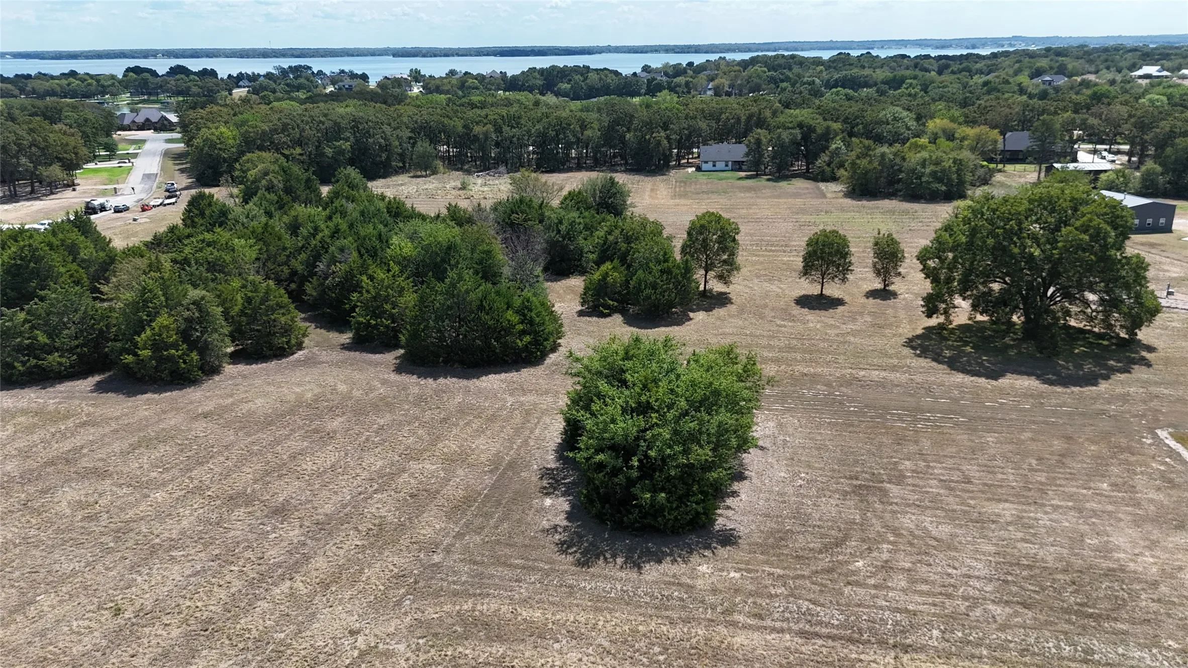 Expansive land parcel featuring mature trees, native vegetation, and water frontage