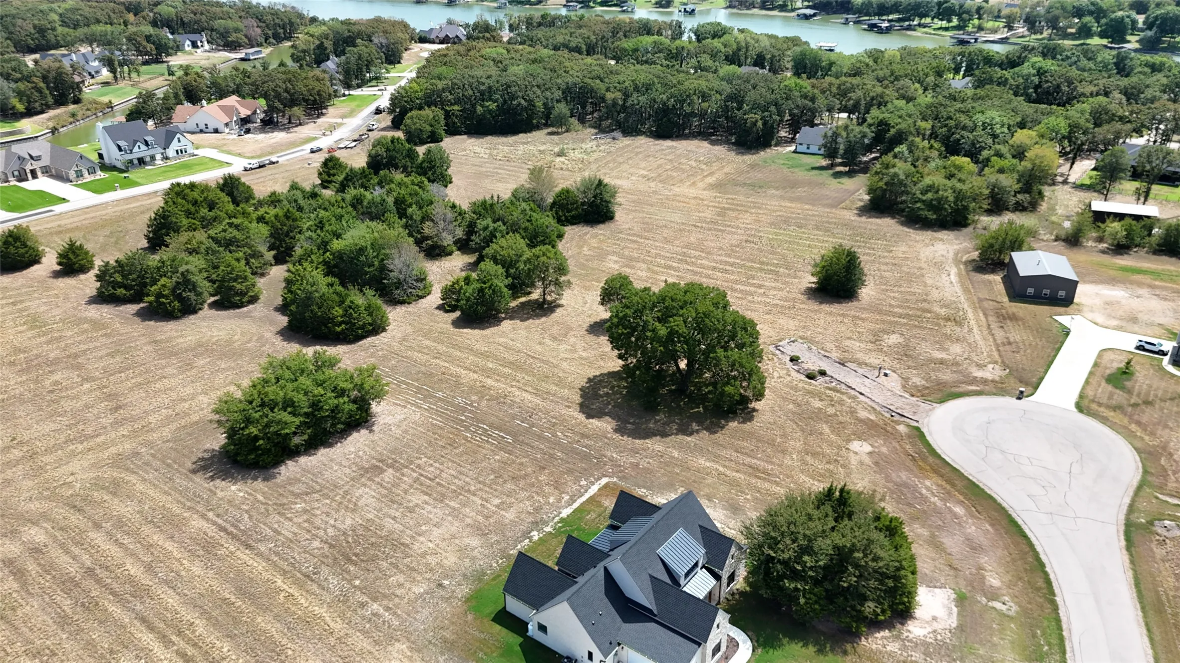 Expansive lot featuring mature trees, paved cul-de-sac access, and open acreage