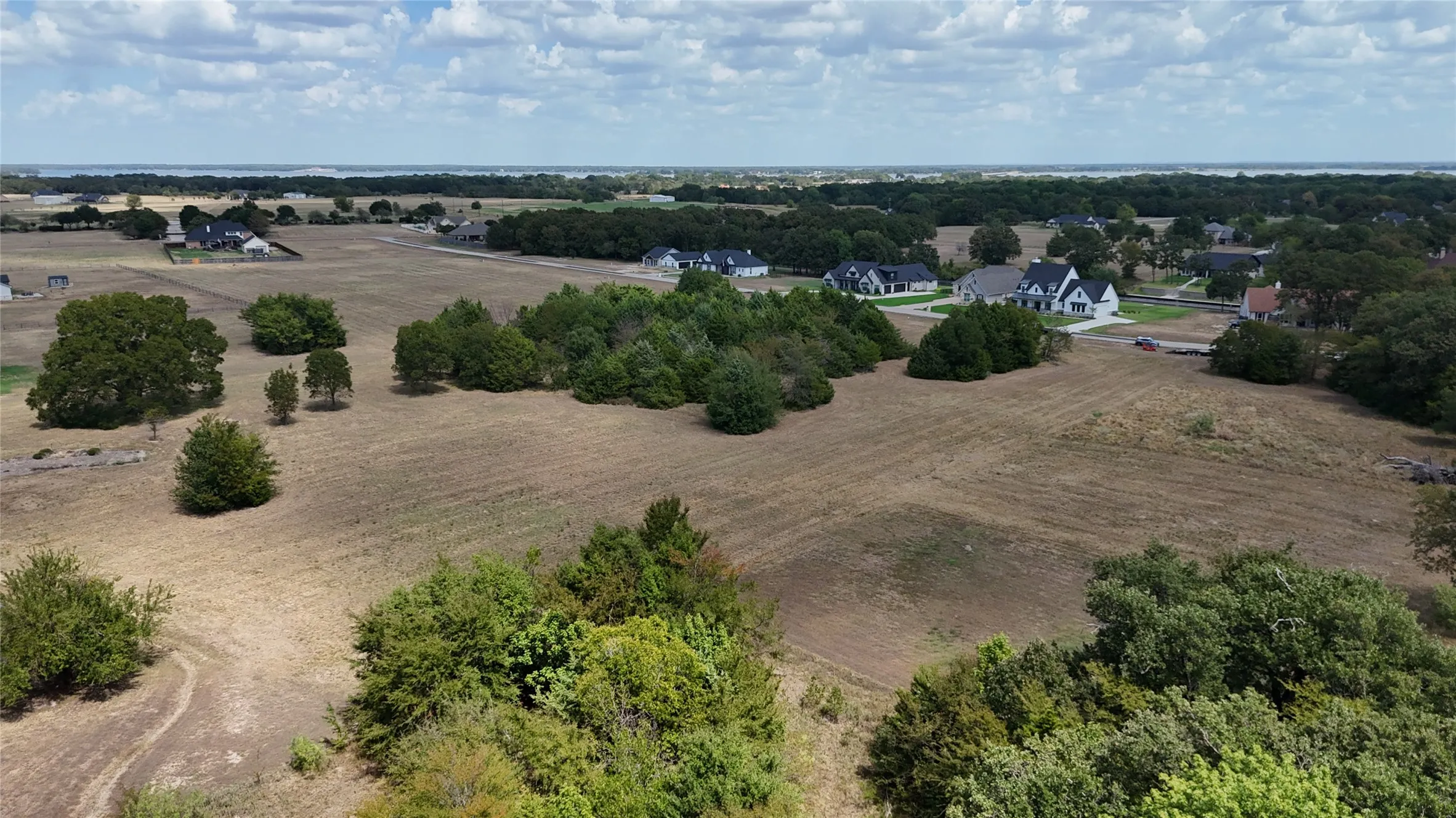 Expansive acreage featuring mature tree clusters, open meadow landscape, and level topography