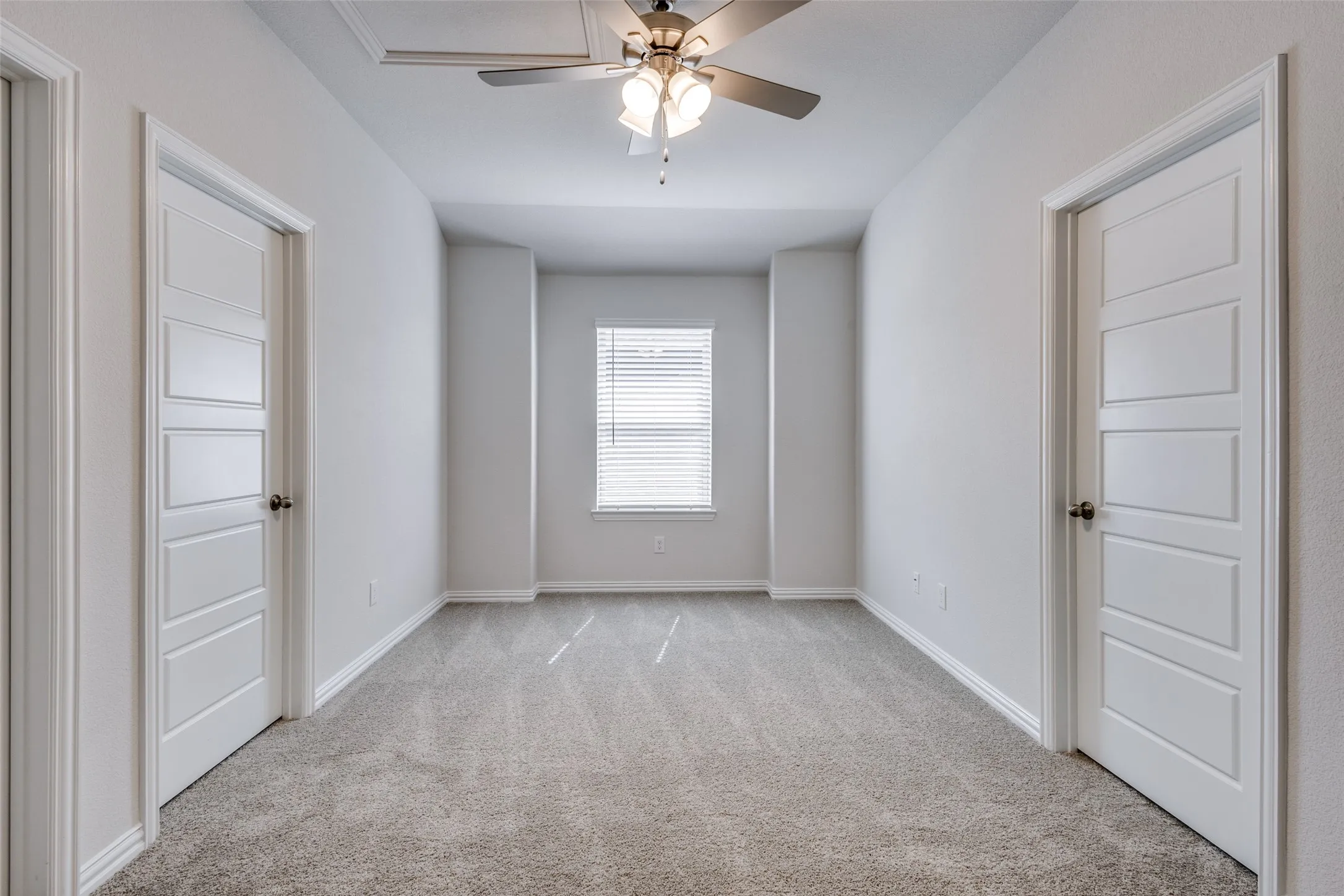 Unfurnished room featuring baseboards, light carpet, and ceiling fan