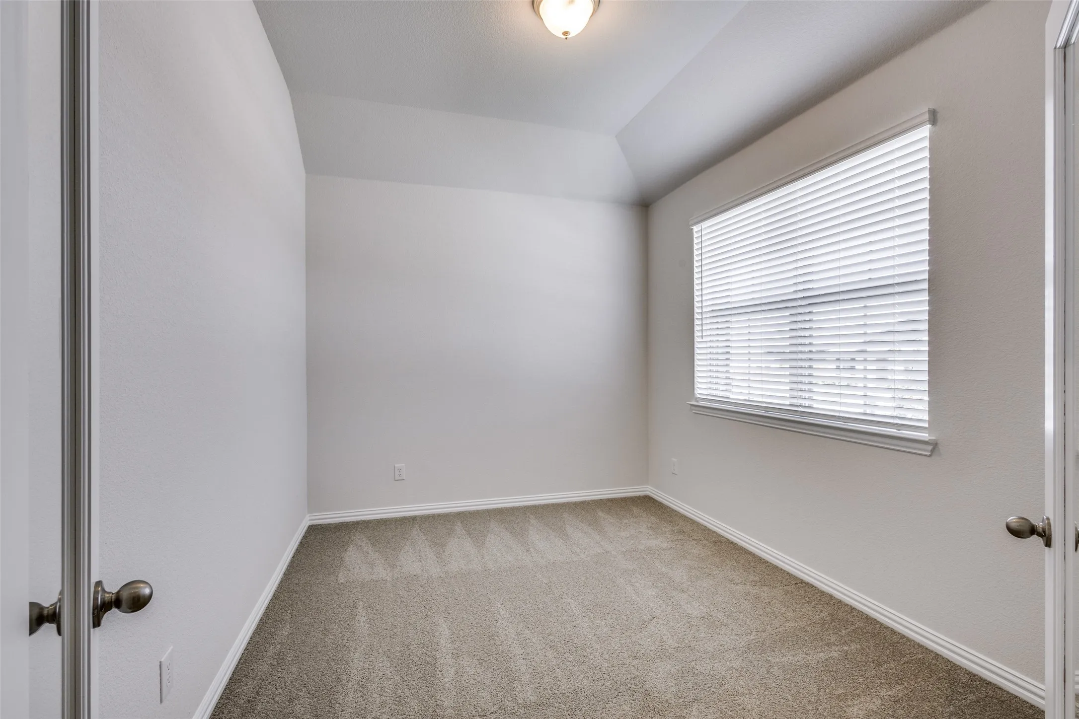 Carpeted spare room with baseboards