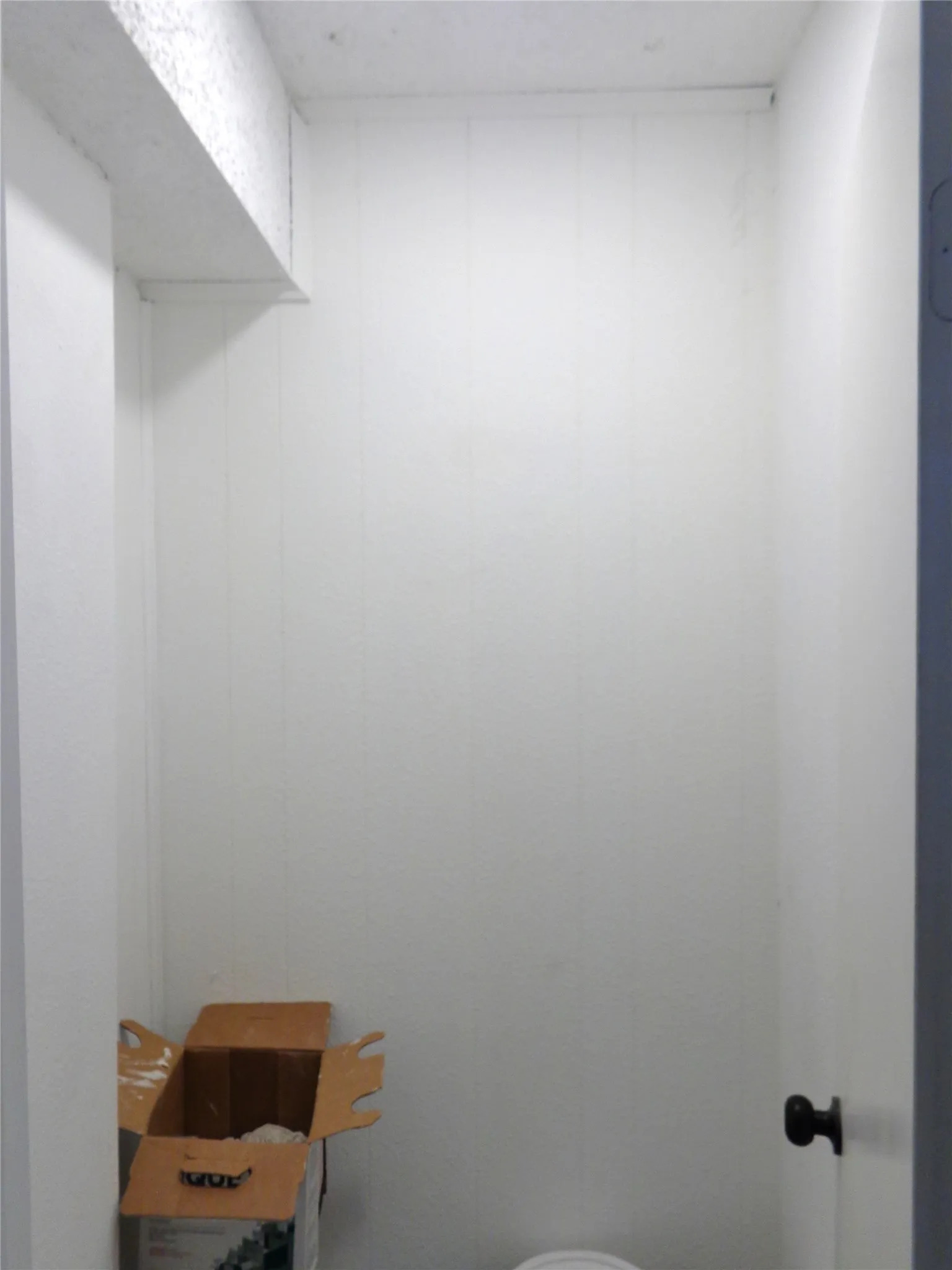 Interior storage alcove featuring white vertical paneling and a structural beam protrusion