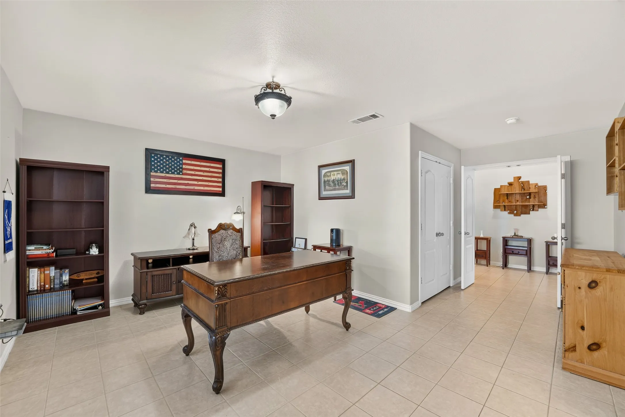 Versatile private study with abundant space for a home office, library, or flex room to fit your lifestyle.  Inner double doors lead to a second pantry. Outer doors lead to hallway.