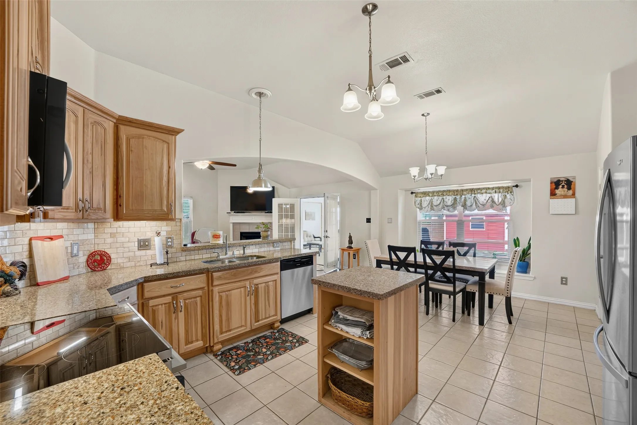 Large entertainment Kitchen featuring Shenandoah cabinetry, Silestone quartz countertops, tile backsplash, center island, and vaulted ceilings