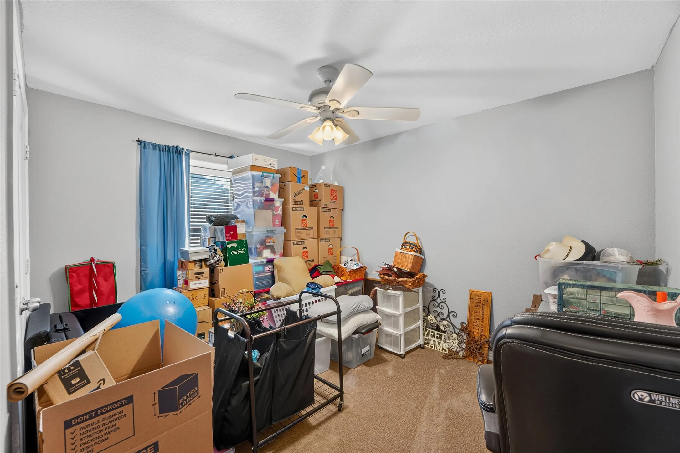Sec. bedroom with ceiling fan currently being used as a staging area for the move.