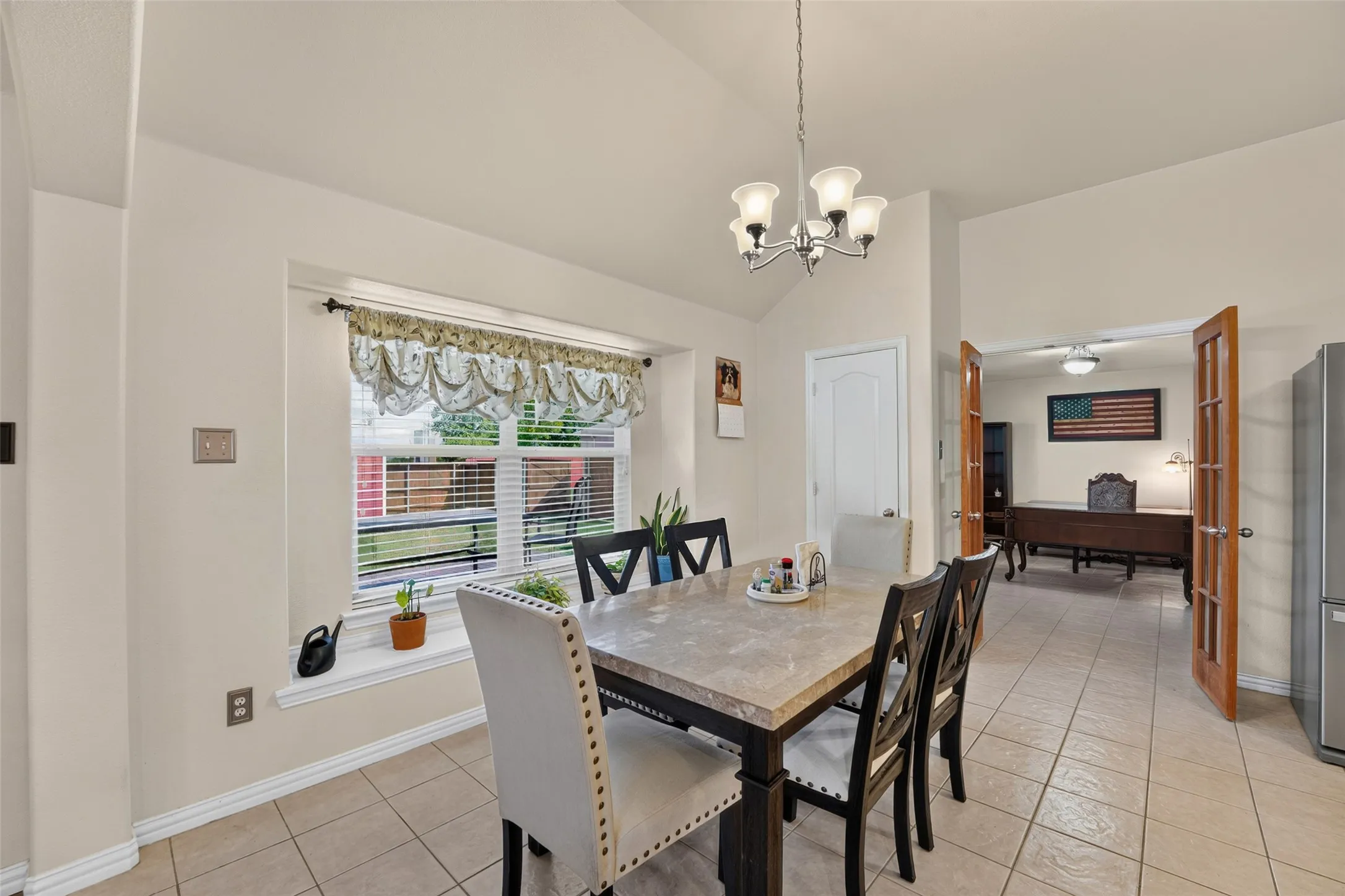 Spacious dining room with vaulted ceiling, large picture window with a charming window seat, and abundant natural light.