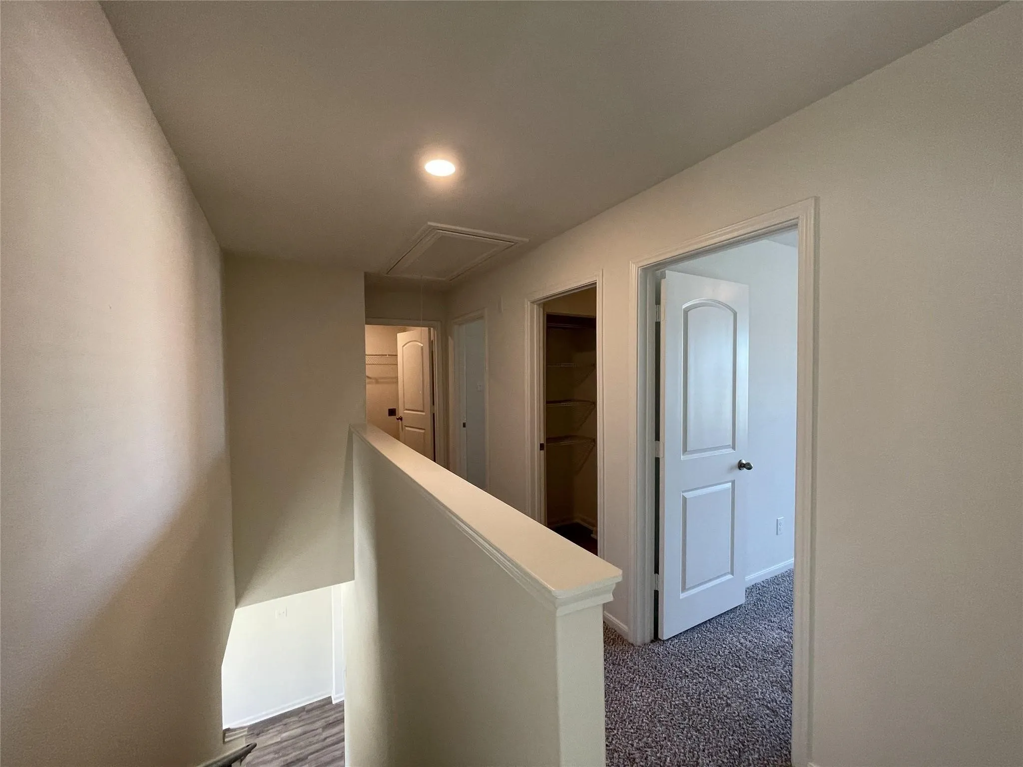 Neutral-toned interior featuring recessed lighting, carpeted flooring, raised-panel interior doors, and built-in closet shelving