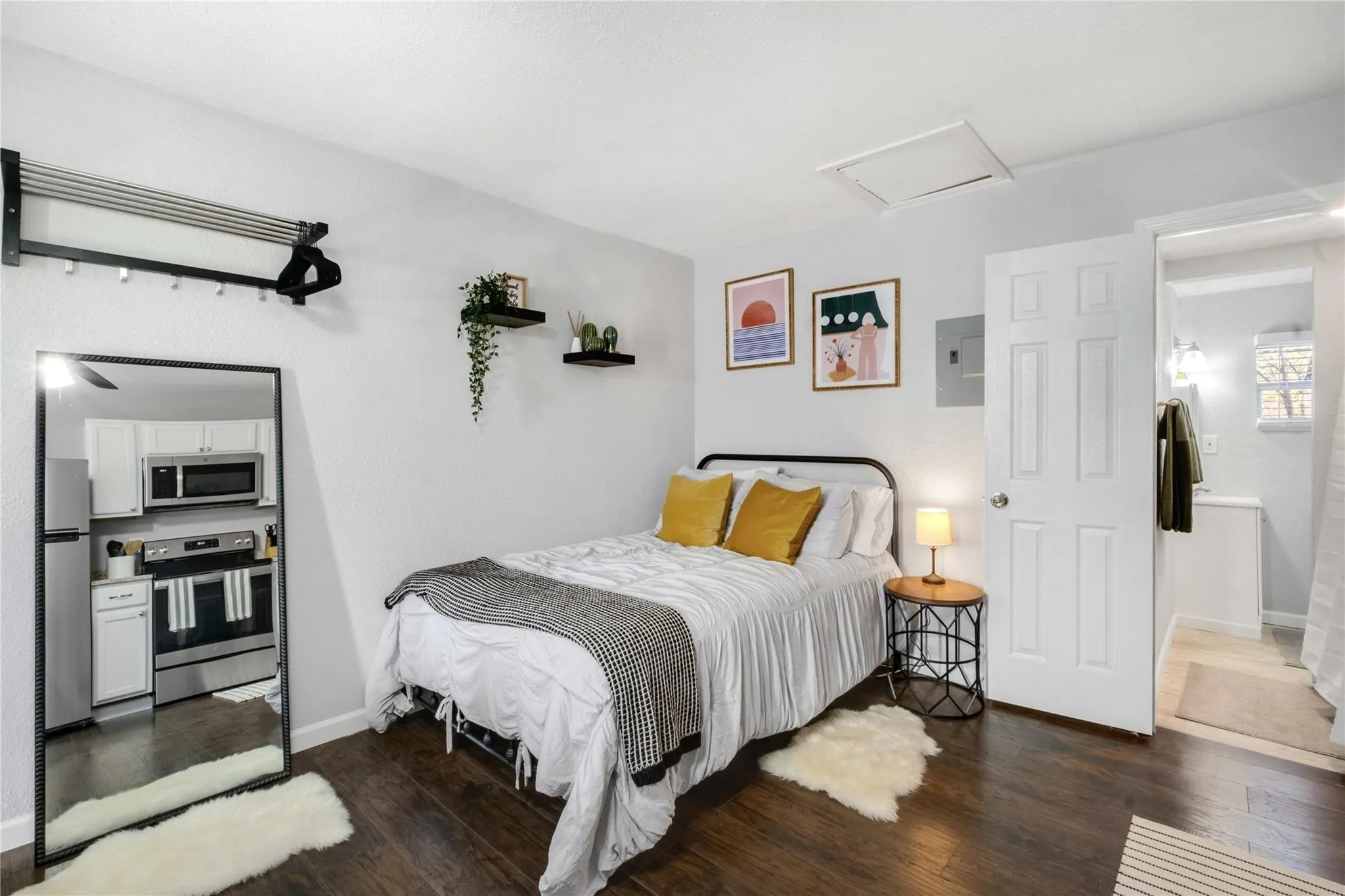 Wood-finish flooring, two wall-mounted floating shelves, and a six-panel interior door