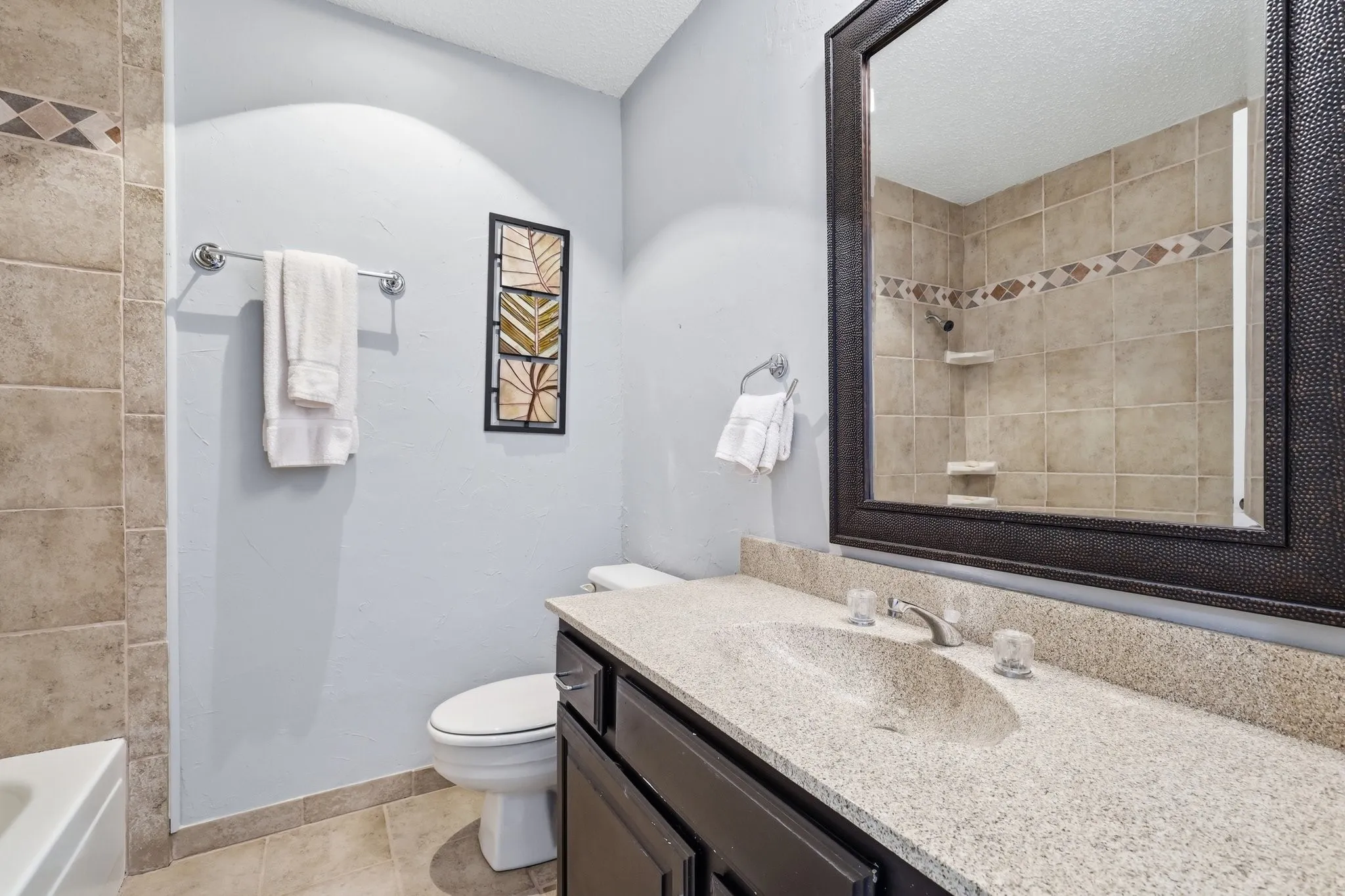Secondary full bath upstairs has shower and tub combo and granite counters.