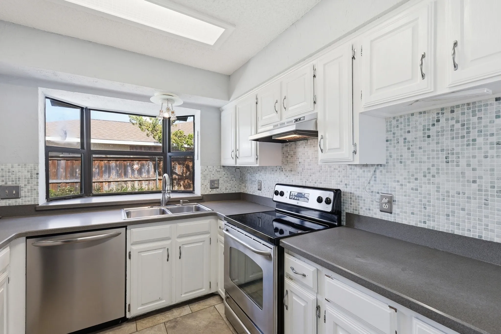 Stainless appliances with natural stone countertops.