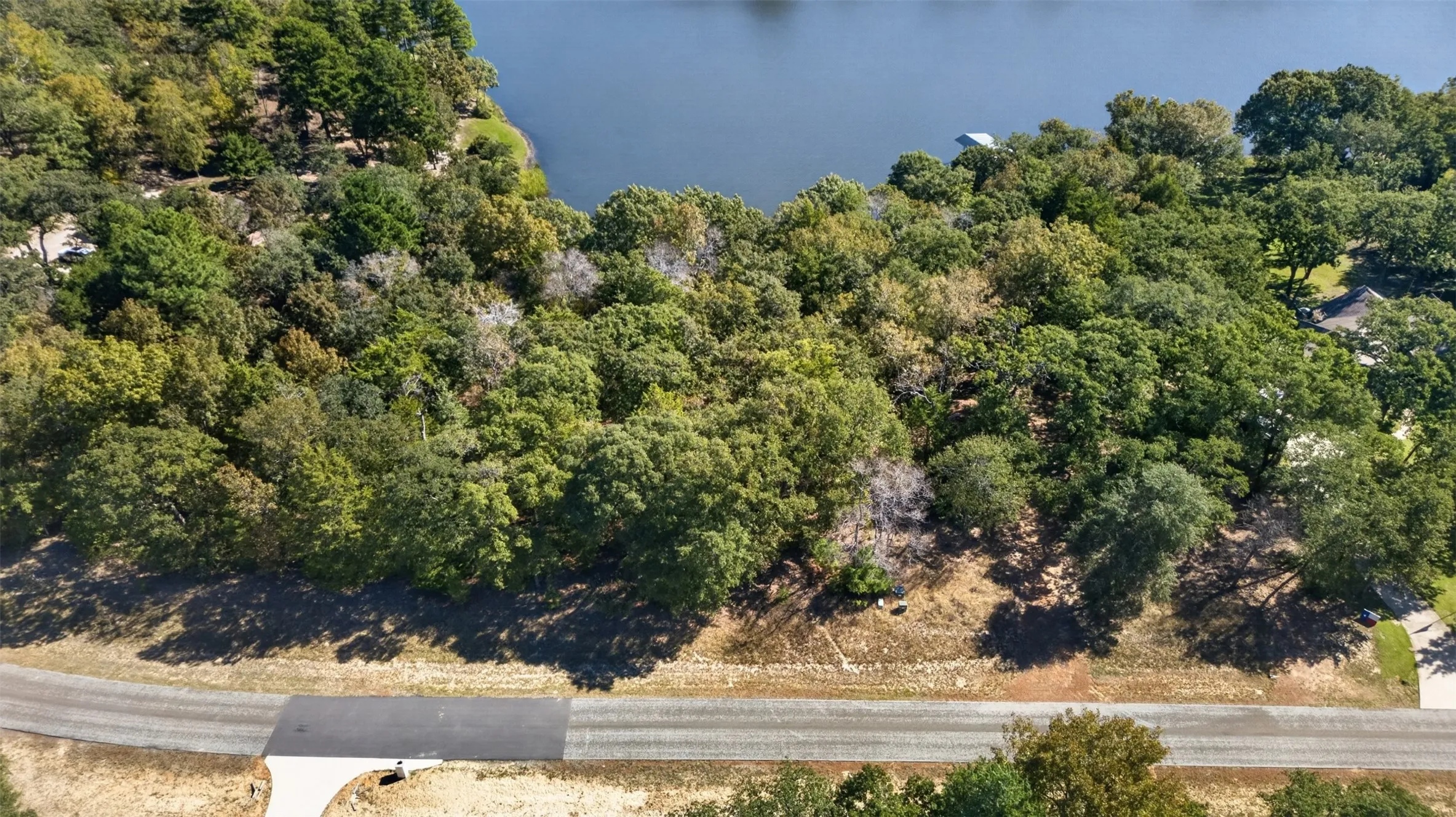Waterfront lot featuring mature tree canopy, varied topography, and direct access to the water's edge