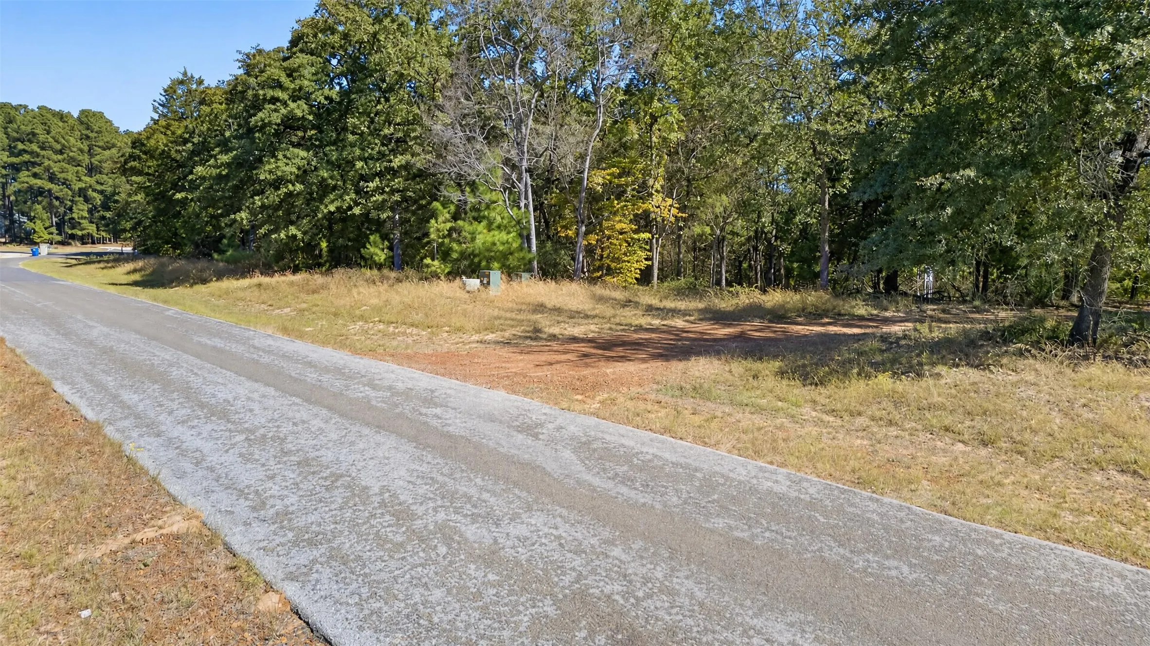 Vacant lot featuring paved road frontage, natural topography, and mature trees