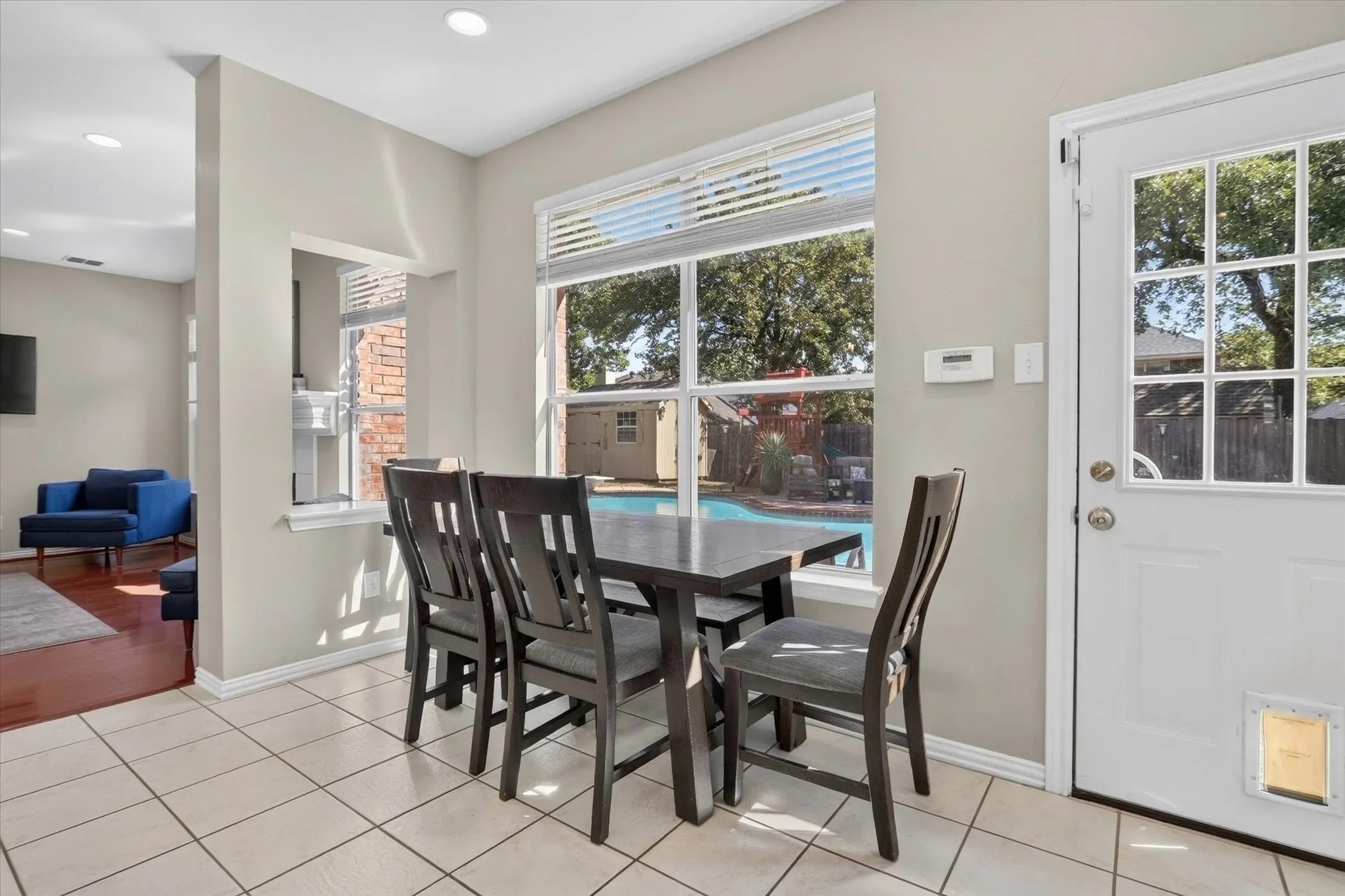 Breakfast area featuring ceramic tile flooring, a large window with blind treatments, recessed lighting, and a multi-pane door with an integrated pet door