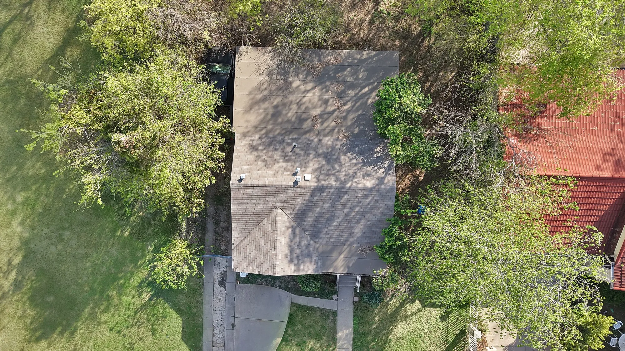 Aerial view showcasing a generous yard with mature landscaping, manicured lawn, and established trees providing natural privacy