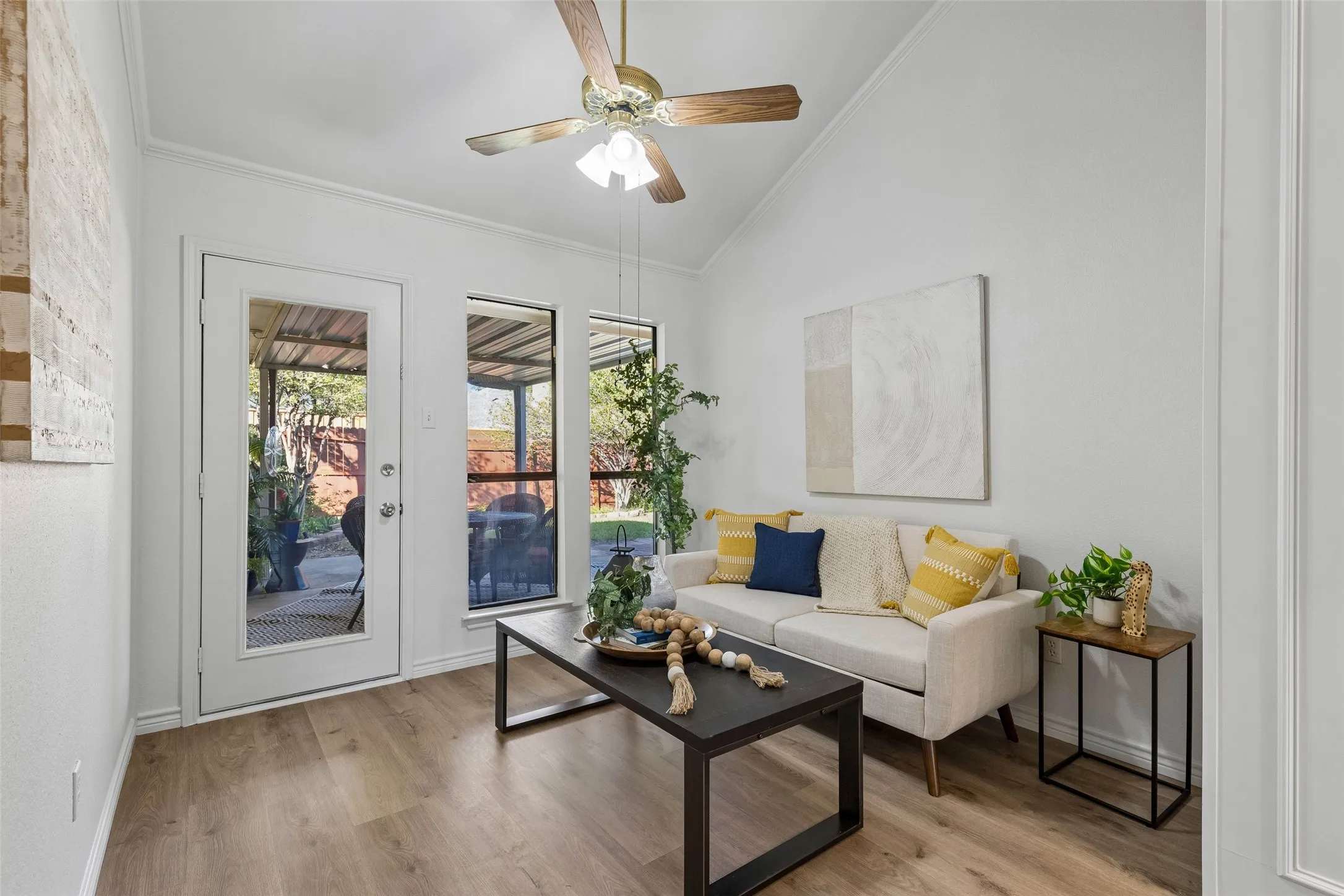Vaulted ceiling with an integrated wooden ceiling fan, wood-finish flooring, and full-lite glass exterior door