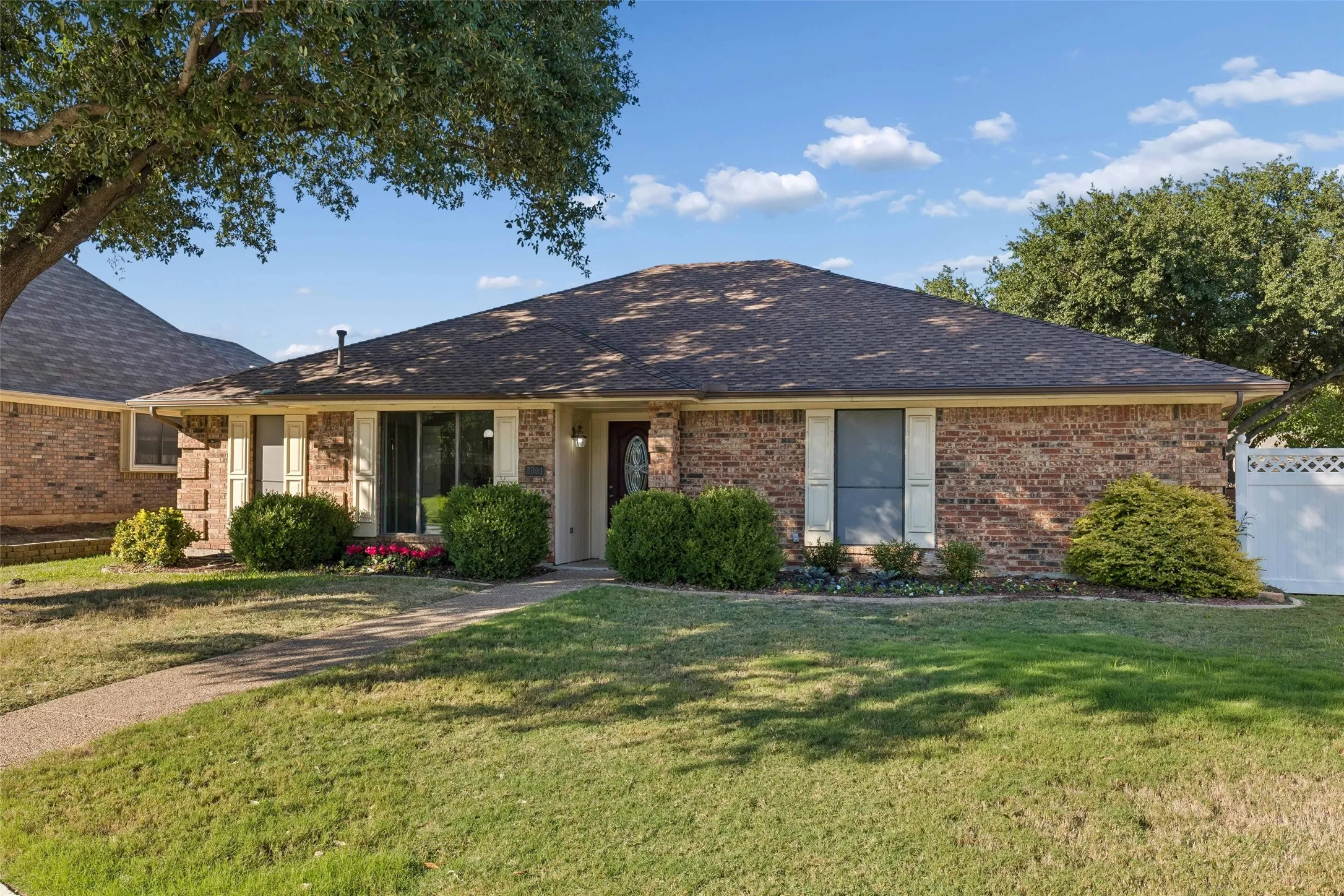 Single-story brick exterior featuring a hip roof, window shutters, and a covered entry