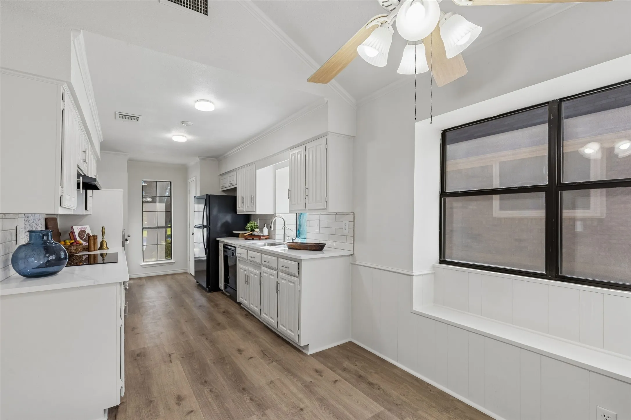 Kitchen featuring white cabinetry, wood-finish flooring, built-in window seat, subway tile backsplash, and recessed lighting