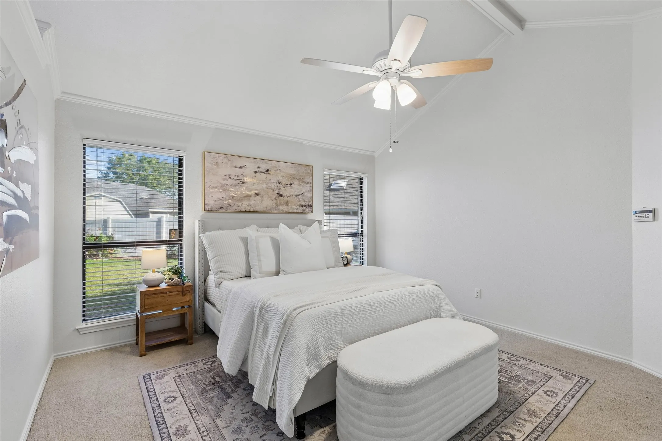Vaulted ceiling with a white-finish paddle ceiling fan, neutral wall-to-wall carpeting, and large dual-pane windows with horizontal blinds