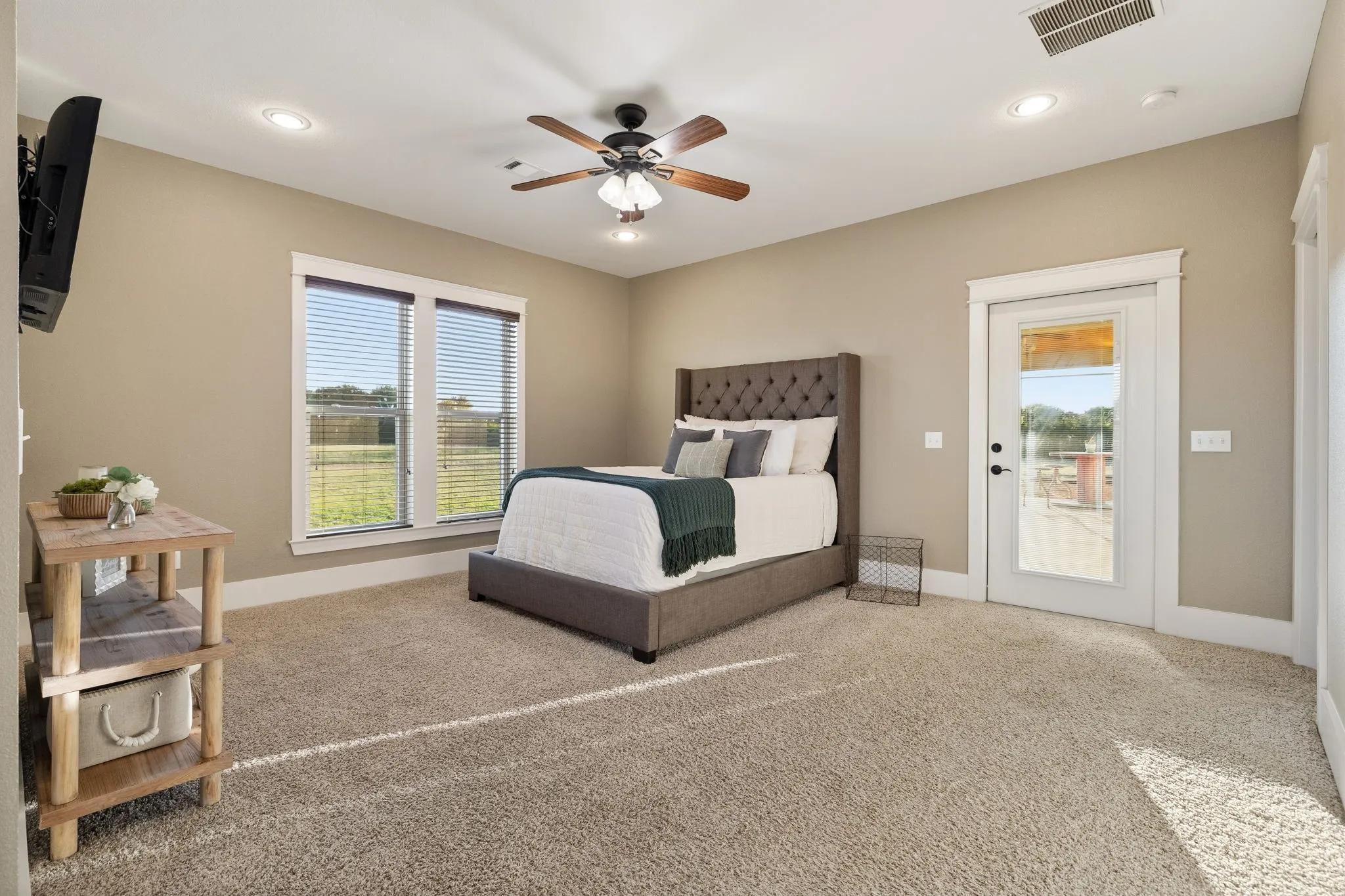 Neutral-toned interior featuring recessed lighting, a multi-blade ceiling fan, wall-to-wall carpeting, and a glass-paneled exterior door