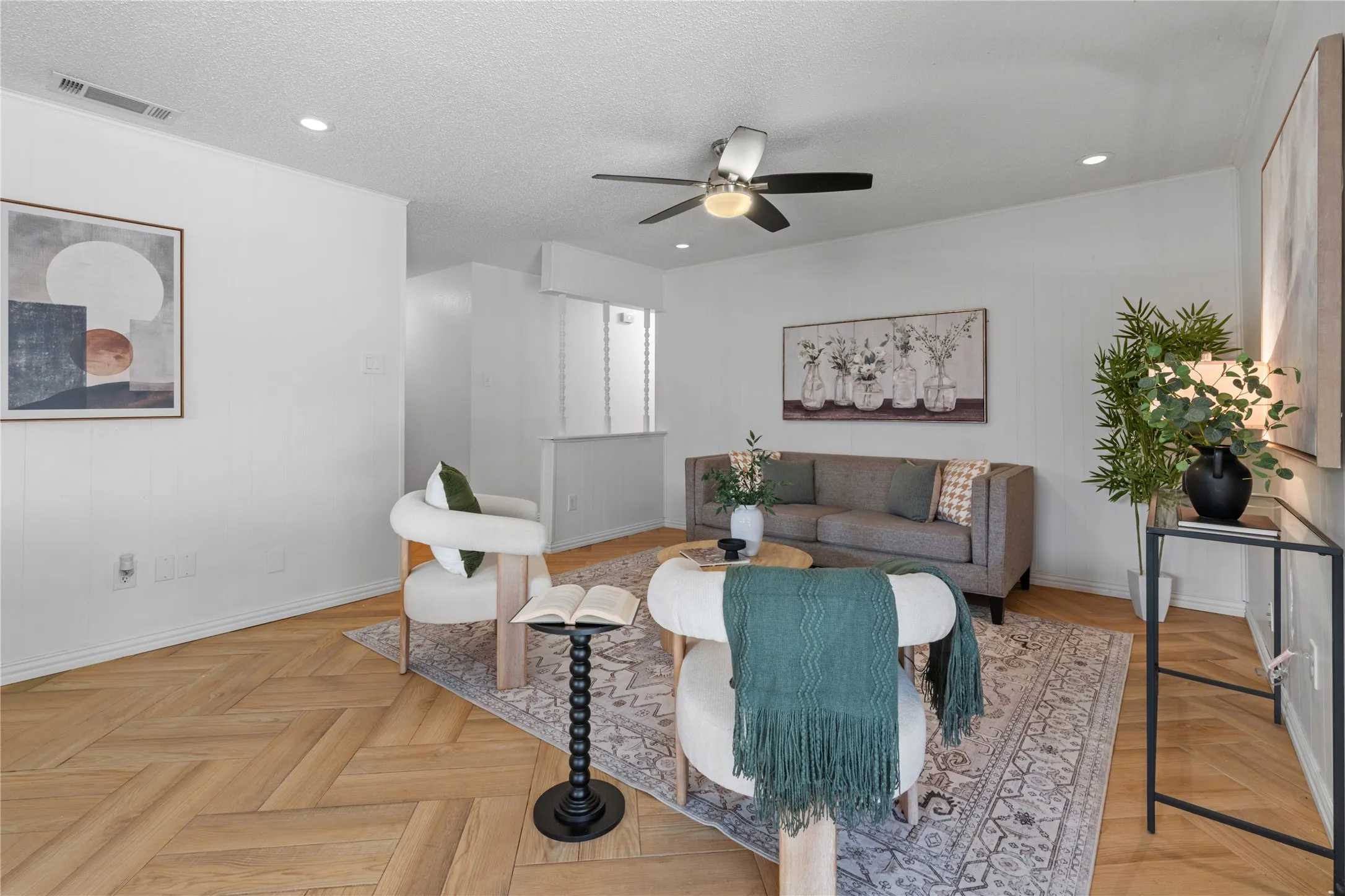 Living area featuring herringbone-pattern wood-finish flooring, recessed lighting, and a ceiling fan with integrated light fixture