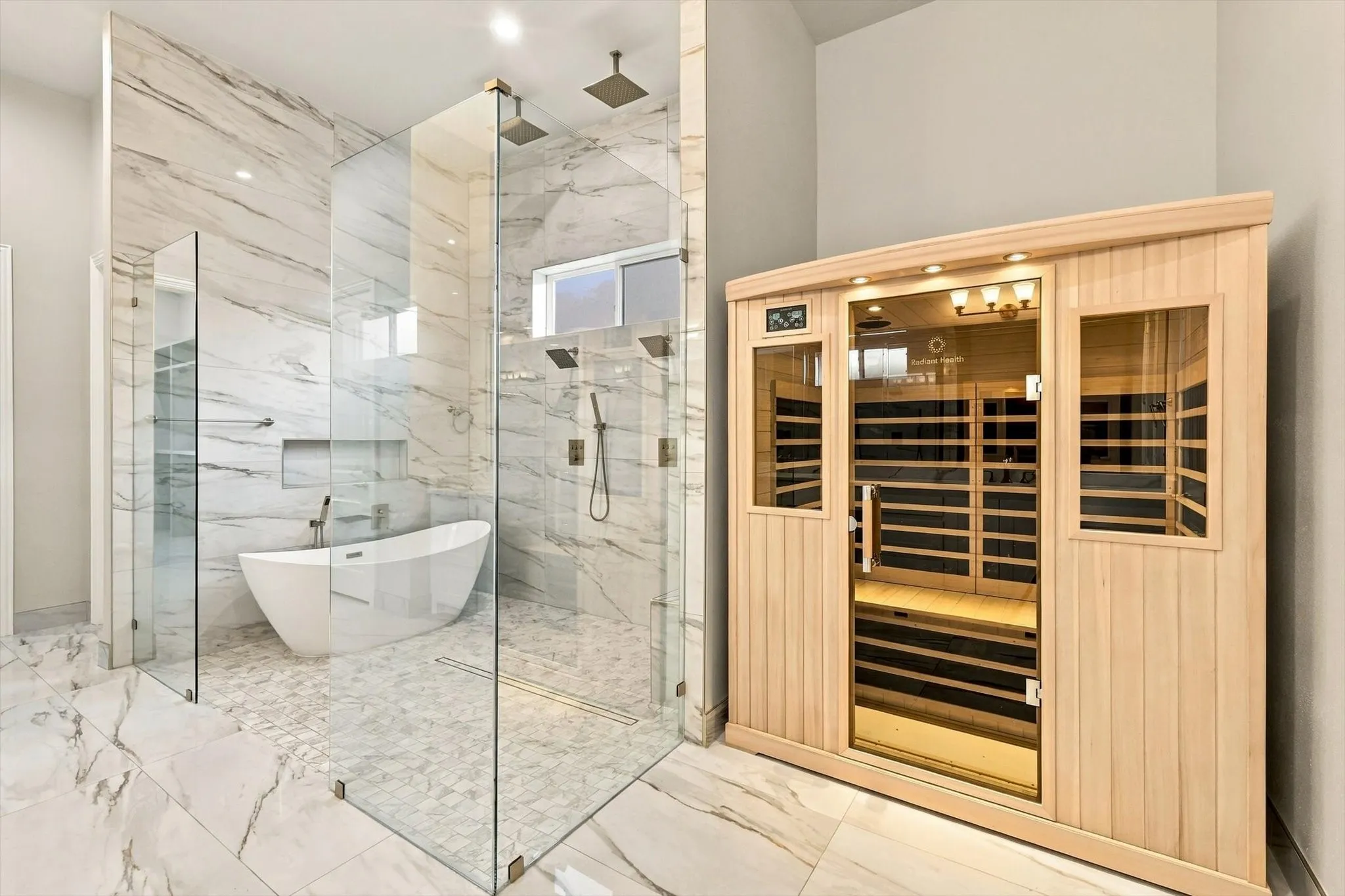 Walk-in shower with floor-to-ceiling veined tile, integrated rainfall showerhead, and handheld sprayer
