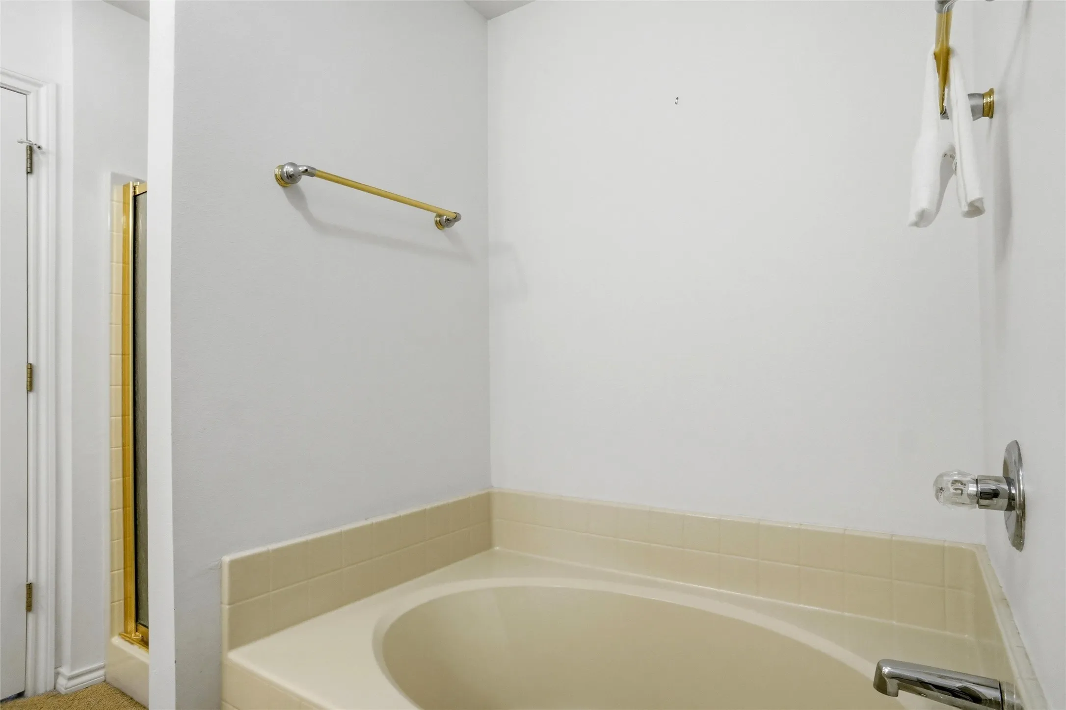 Alcove bathtub with tile surround, polished chrome fixtures, and a separate glass-enclosed shower