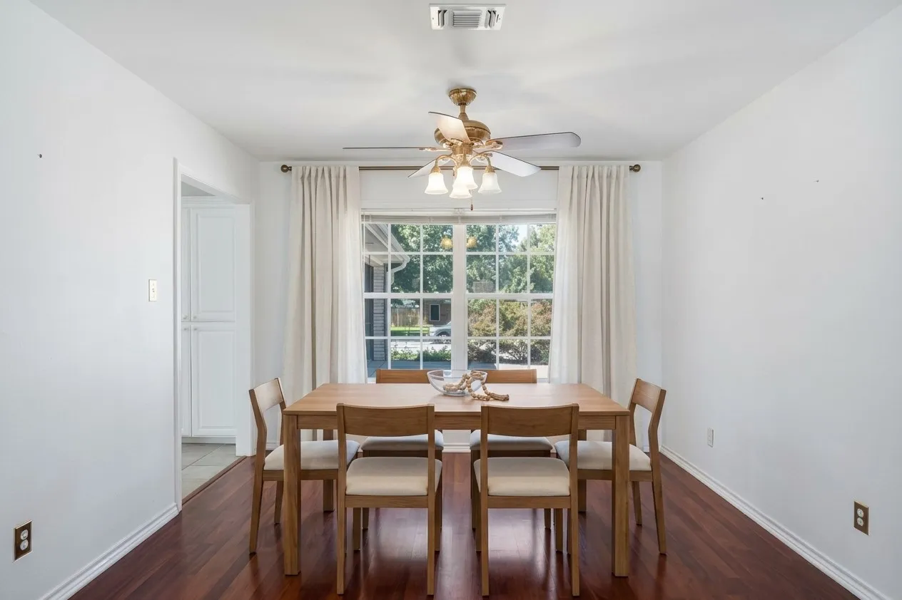 AI enhanced photo.  Beautiful laminate flooring, white walls, and a multi-pane window with drapes