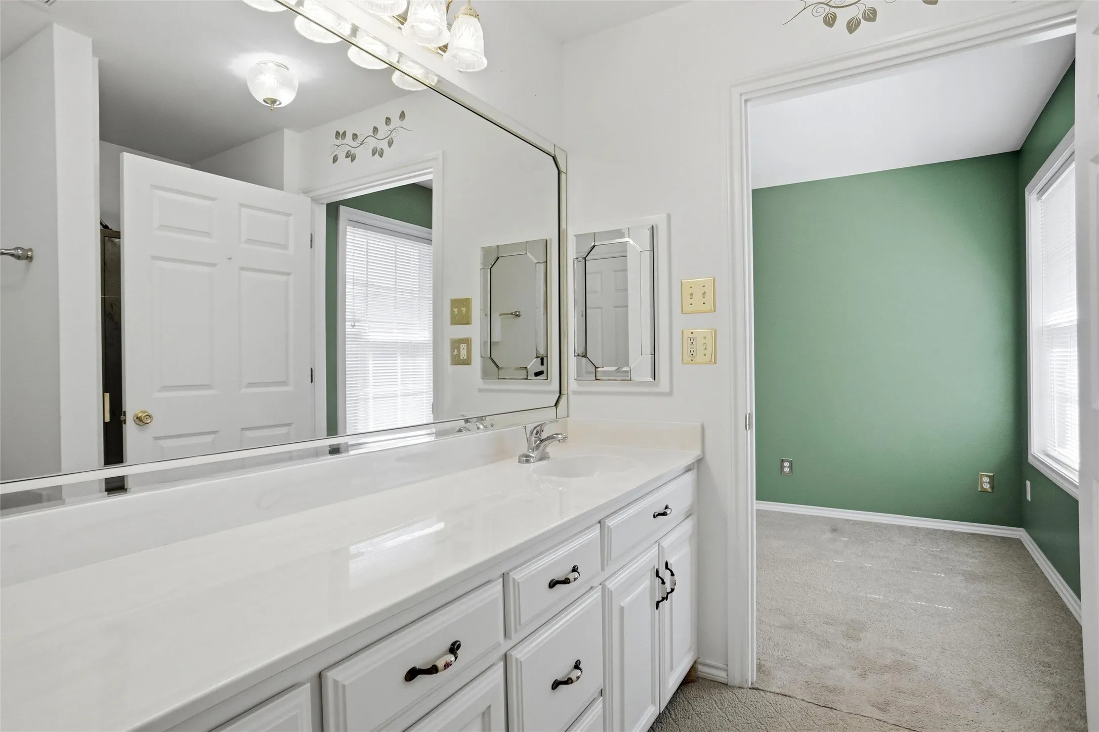 Bathroom vanity with white cabinetry, integrated sink, full-width mirror and handy medicine cabinet.