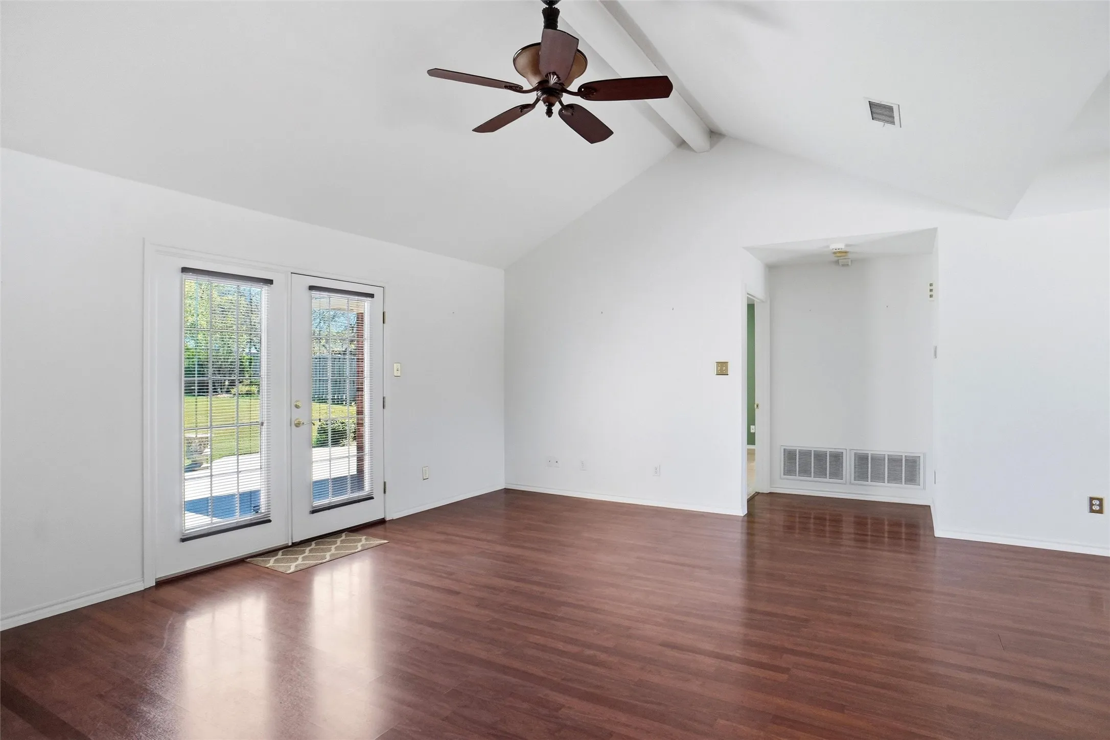 You'll love the airy feel of this room with the vaulted ceiling, beautiful laminate flooring, ceiling fan and double glass-paneled doors.