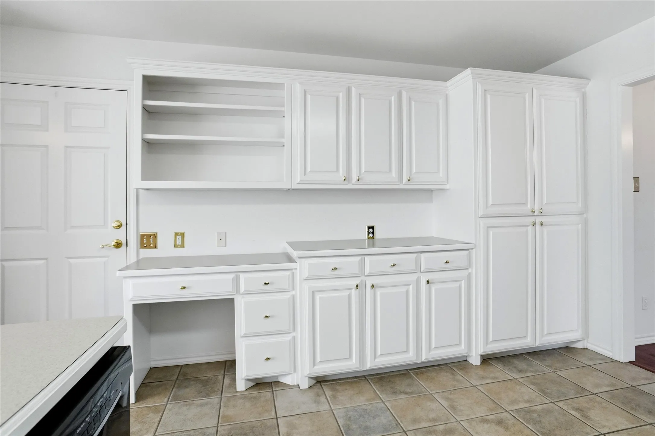 White built-in cabinetry, integrated desk, open shelving, and spacious pantry