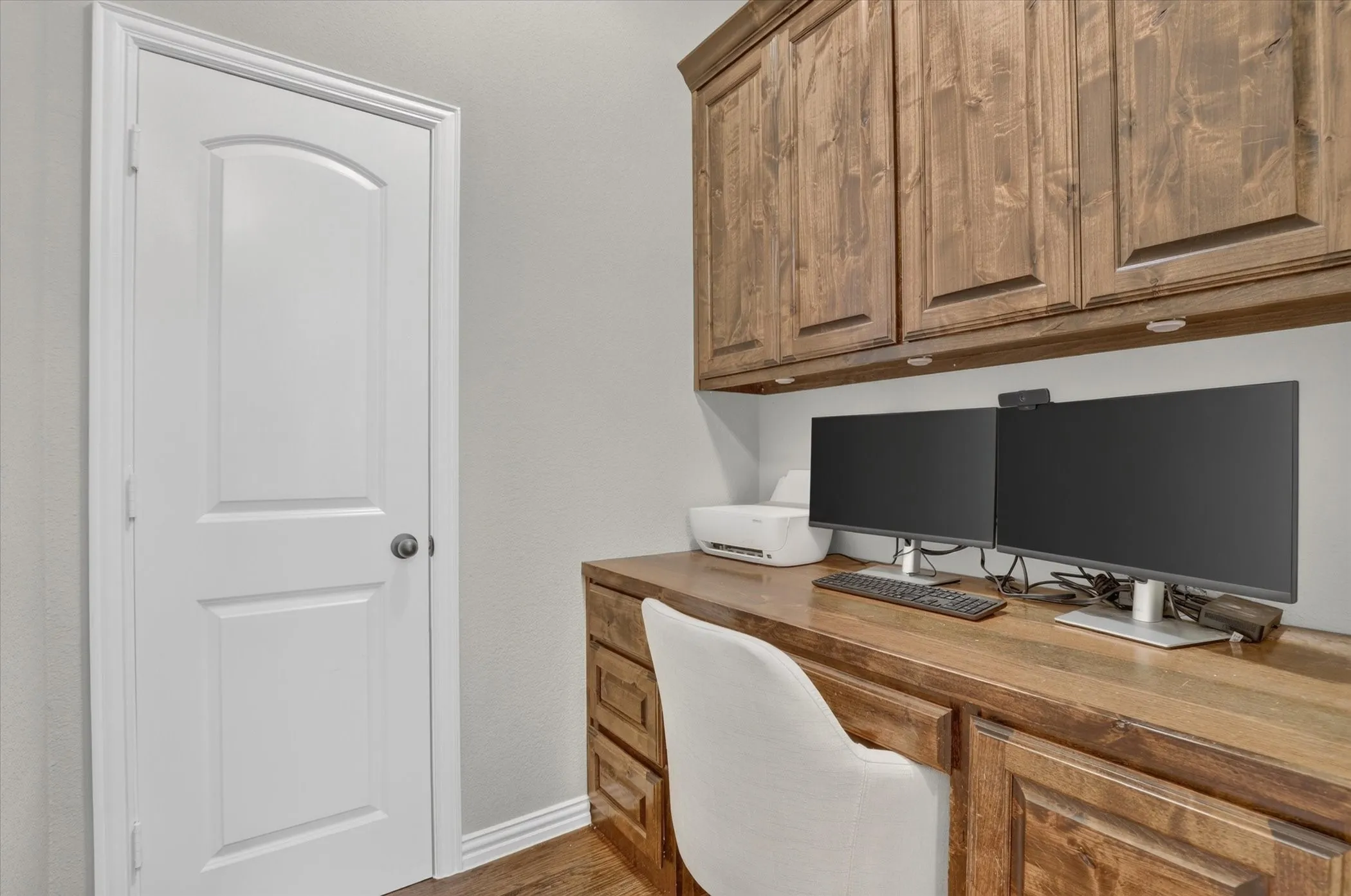 Built-in wood cabinetry with matching desk workspace, drawers, and under-cabinet lighting