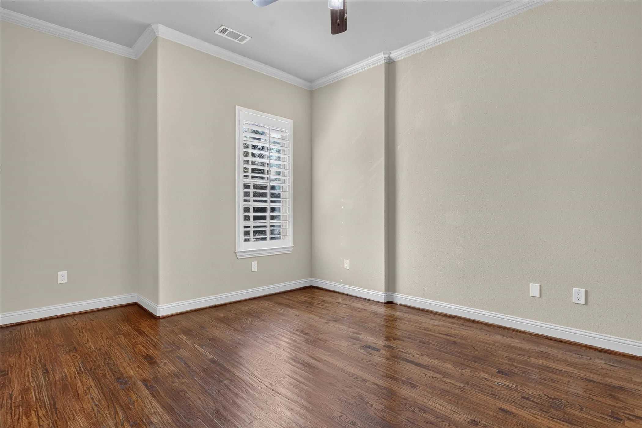 Bedroom 3 on the main level, floor 2, with neutral wall paint, crown molding, and plantation shutters