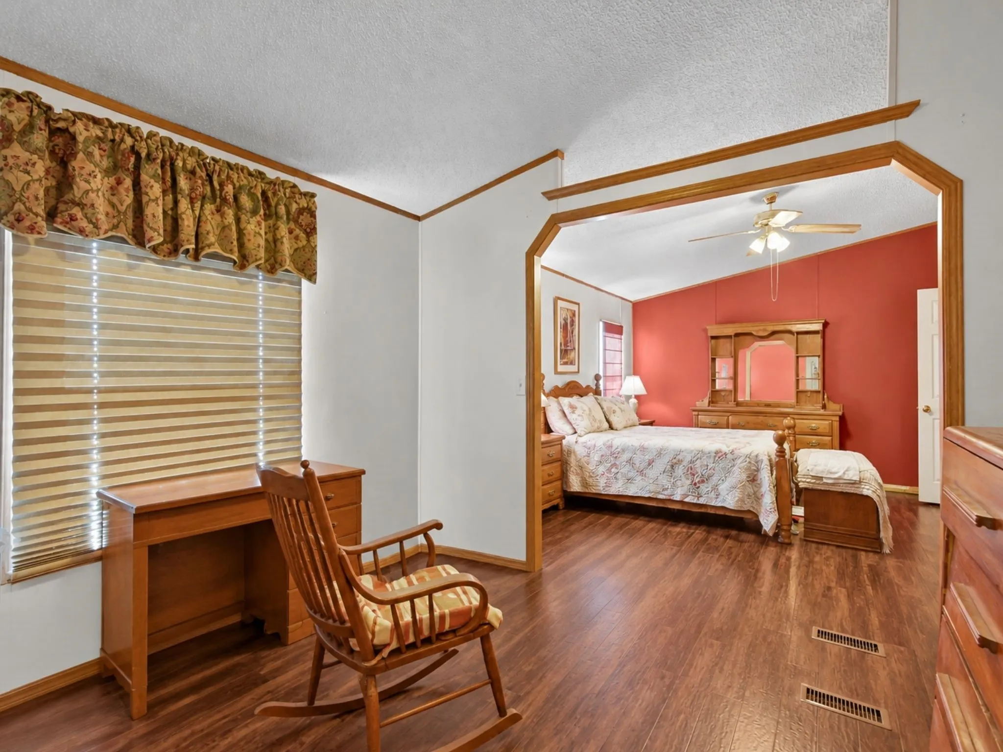 Wood-finish flooring, vaulted ceilings, and architectural pass-through with custom wood trim