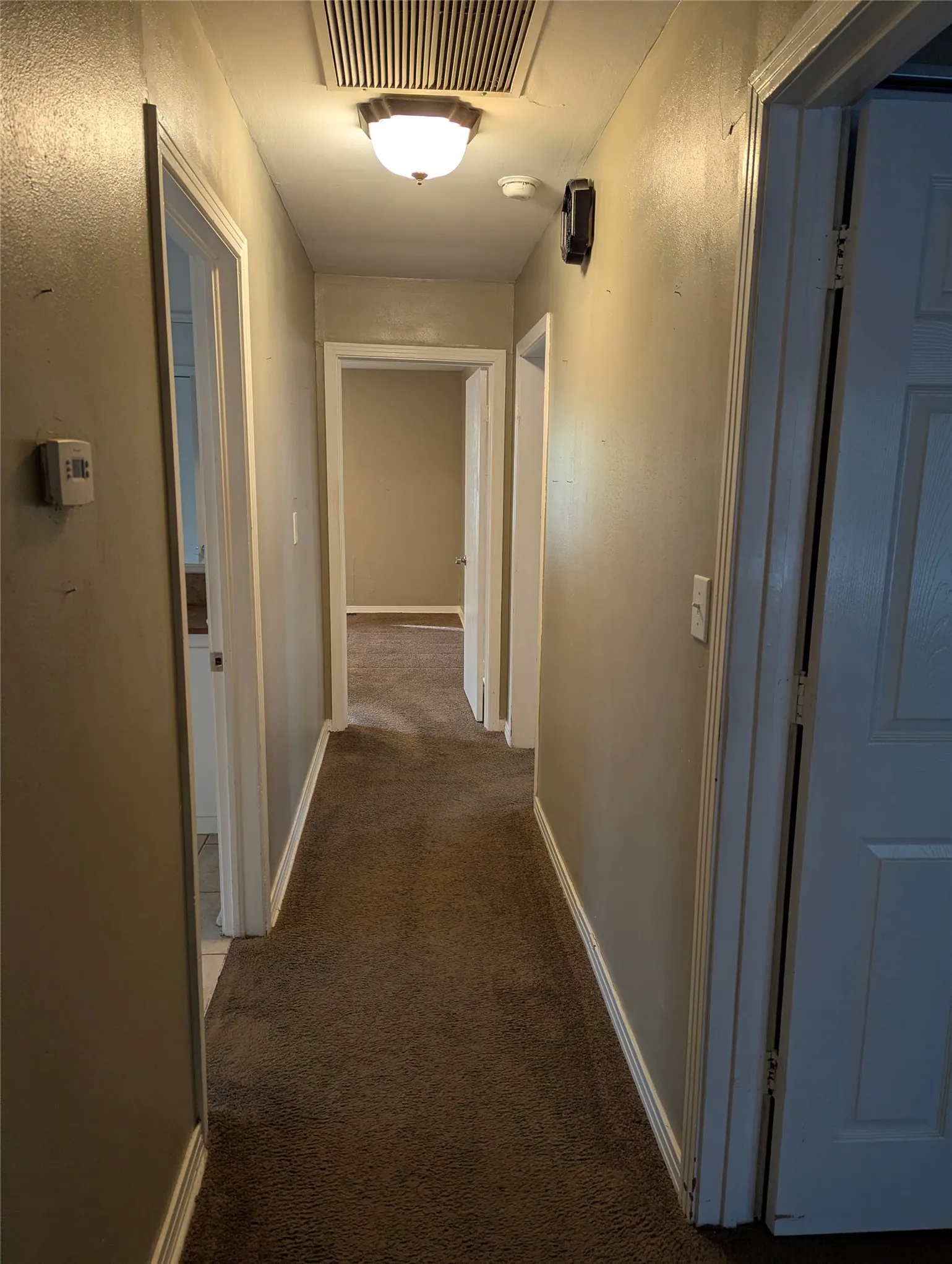 Hallway located on the east side of the living area provides access to all three bedrooms and the full hallway bathroom, with an additional storage closet at the end of the hall.