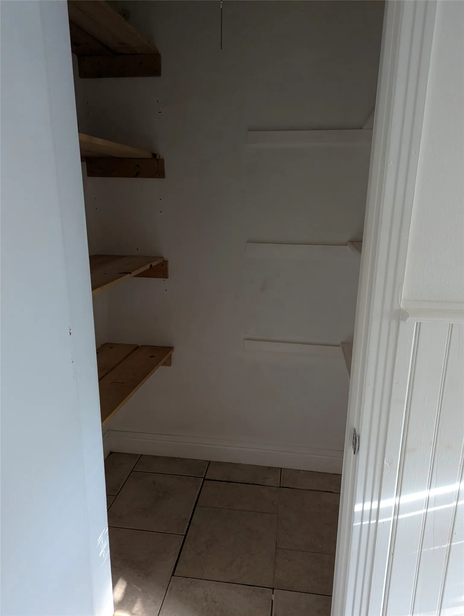 Convenient linen closet with built-in shelving and access to the crawl space serving this section of the home.