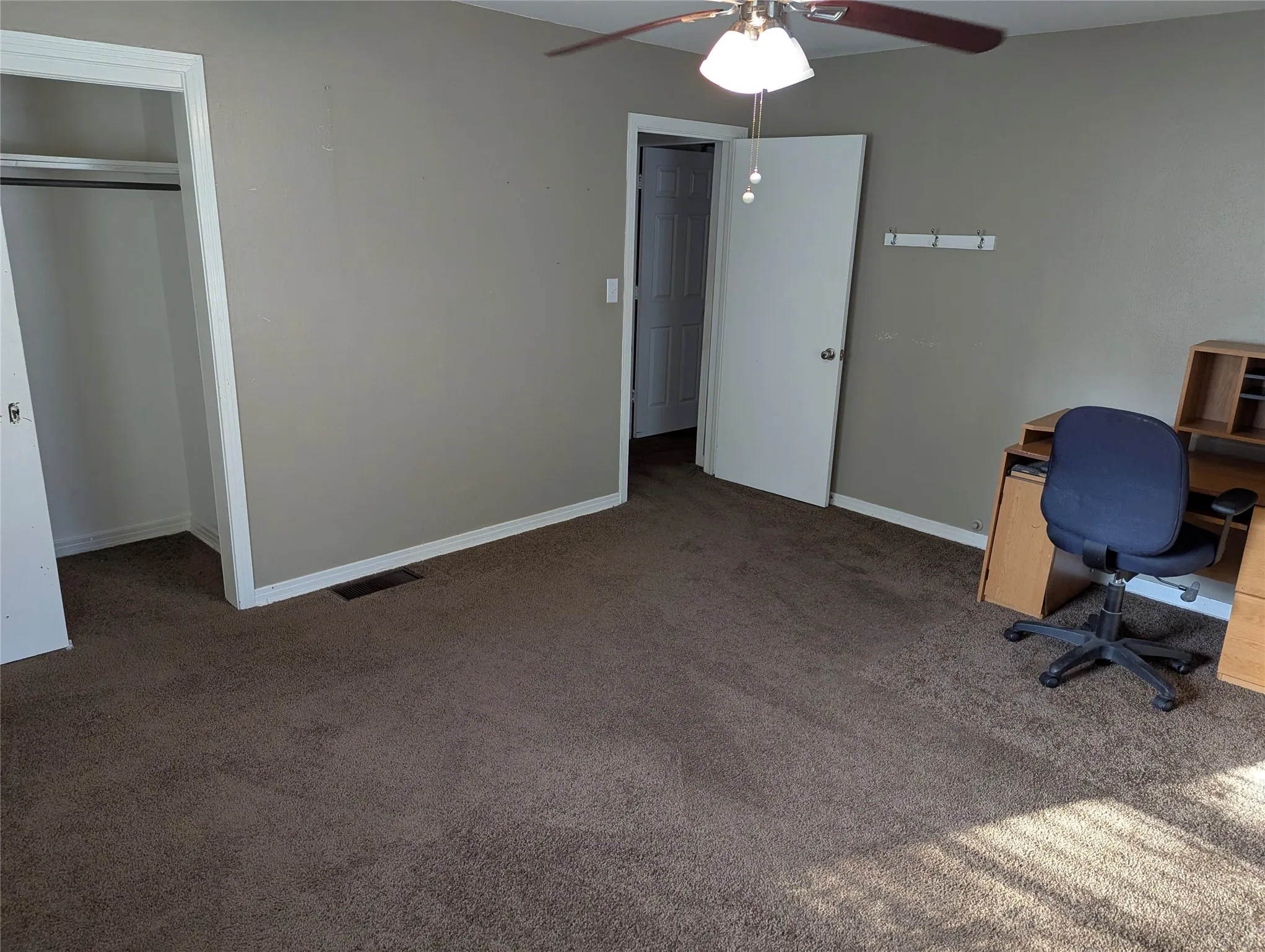 Another view of Bedroom #2, highlighting neutral wall colors, generous floor space, and a convenient closet. Great potential for a bedroom, guest room, or home office!