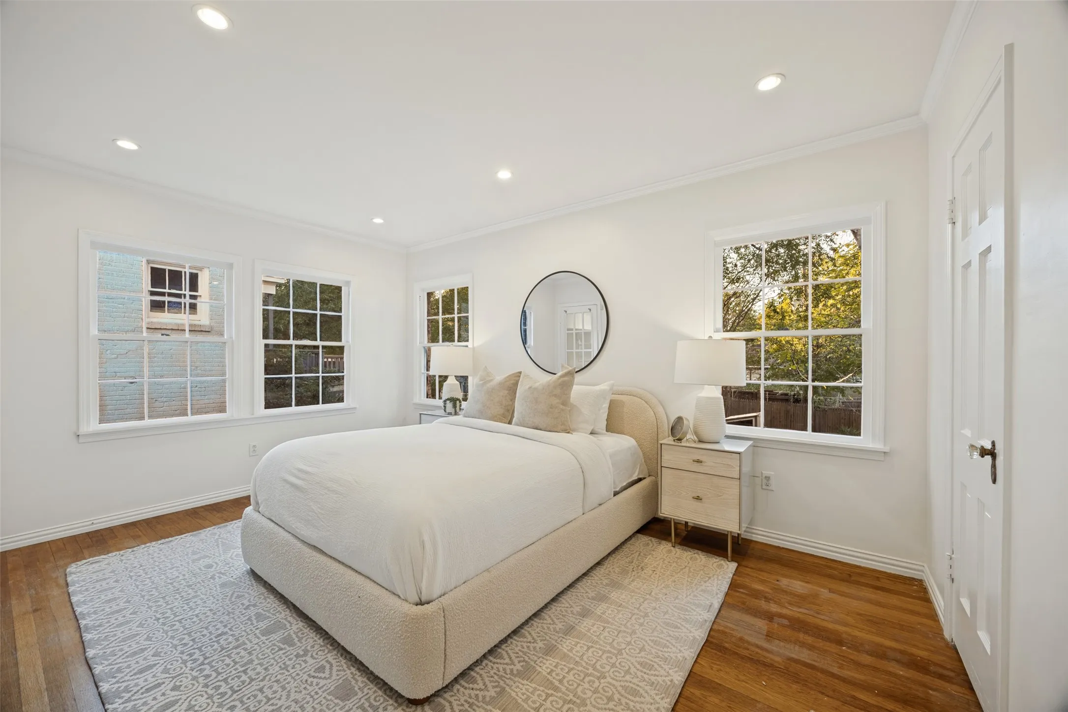 Bright room featuring wood-finish flooring, recessed lighting, multi-pane windows, and crown molding