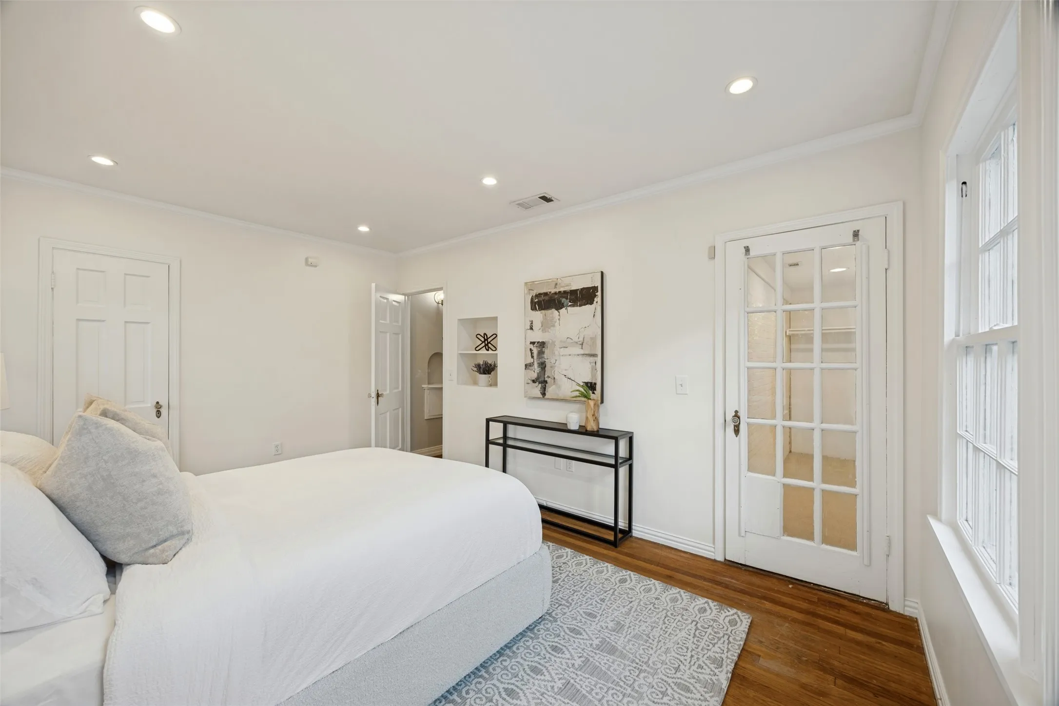 Hardwood flooring, recessed lighting, built-in wall niche, and French door with glass panes