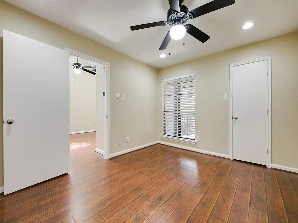 Wood-finish flooring, ceiling fan with integrated light fixture, recessed lighting, and horizontal window blinds