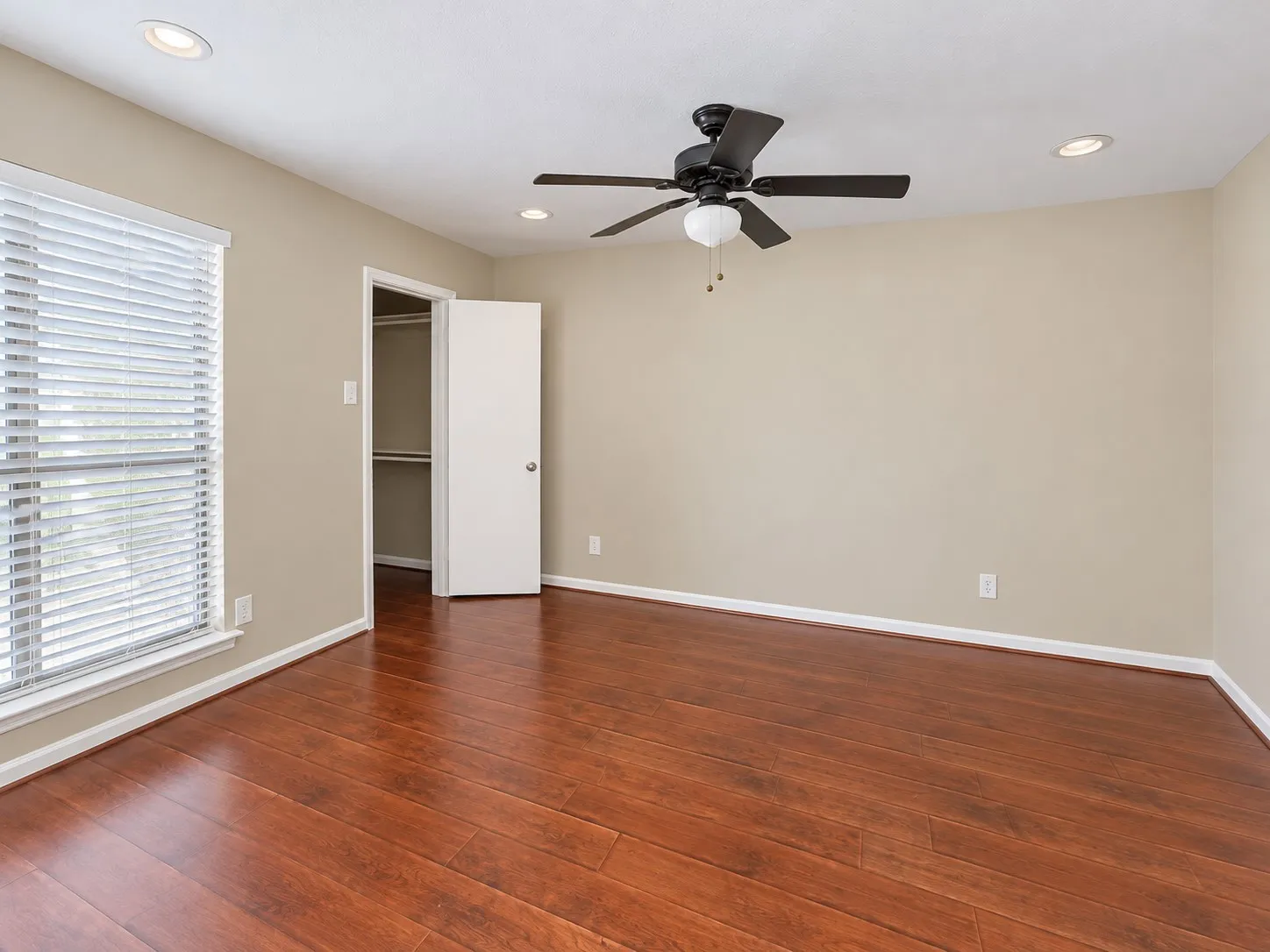 Room featuring wood-finish flooring, recessed lighting, a ceiling fan with integrated lighting, a window with horizontal blinds, and a built-in closet