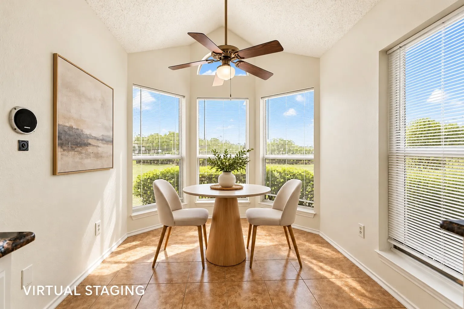 Vaulted ceiling featuring a central blade-style ceiling fan, large windows with horizontal blinds, and ceramic tile flooring
